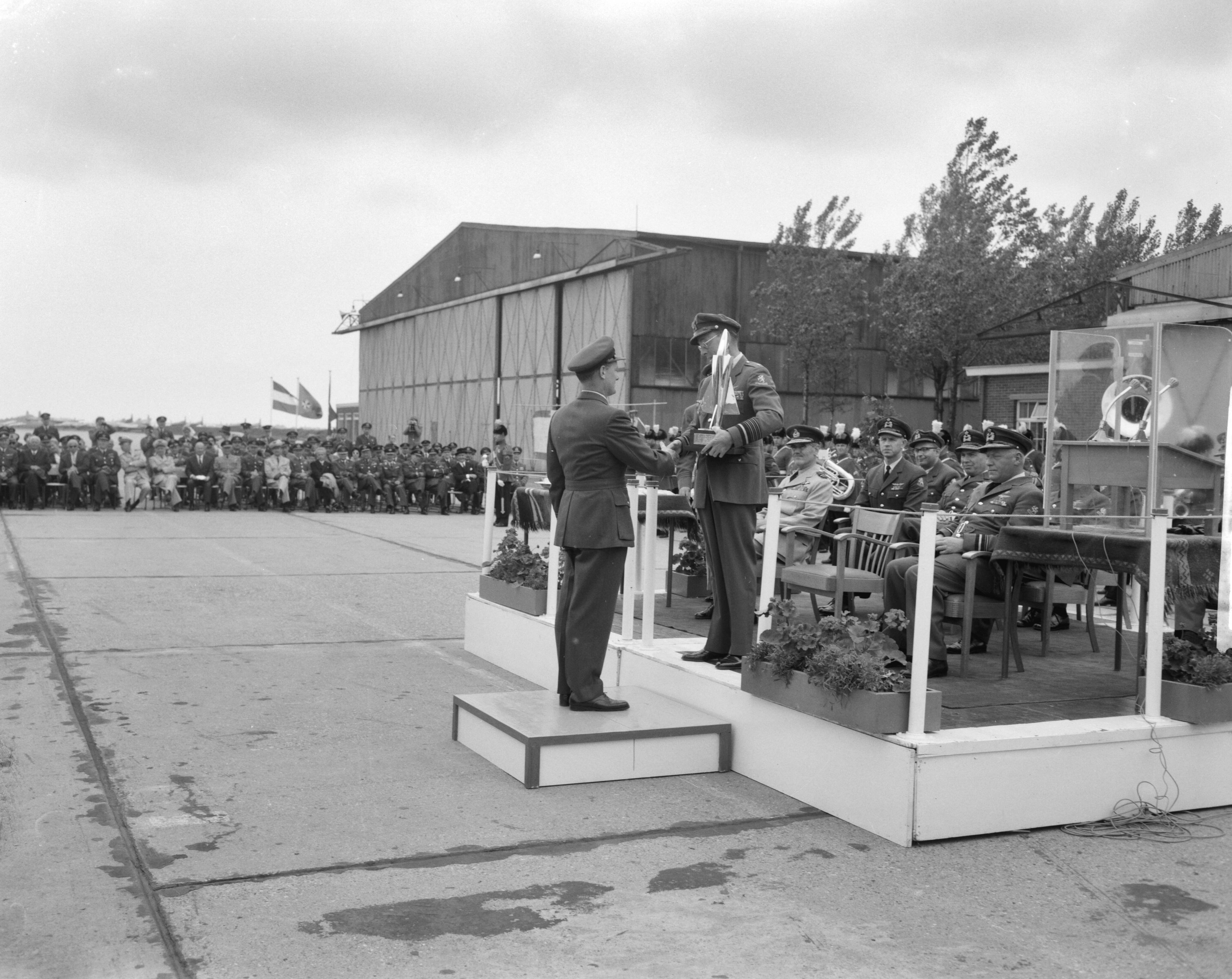 Fotocollectie Anefo — Prins Bernhard reikt in Leeuwarden prijzen uit van 5e Aircent-schietcompetitie van de NAVO luchtmacht. Brian Mercer "squadron-leader" van de winnende Britse ploeg ontving uit handen van de prins de Guynemertrofee — Foto: Bilsen, Joop van / Anefo. Licentie: Set B: Rechtenvrij / Publiek Domein. Bron: Nationaal Archief. http://hdl.handle.net/10648/aa0d6300-d0b4-102d-bcf8-003048976d84