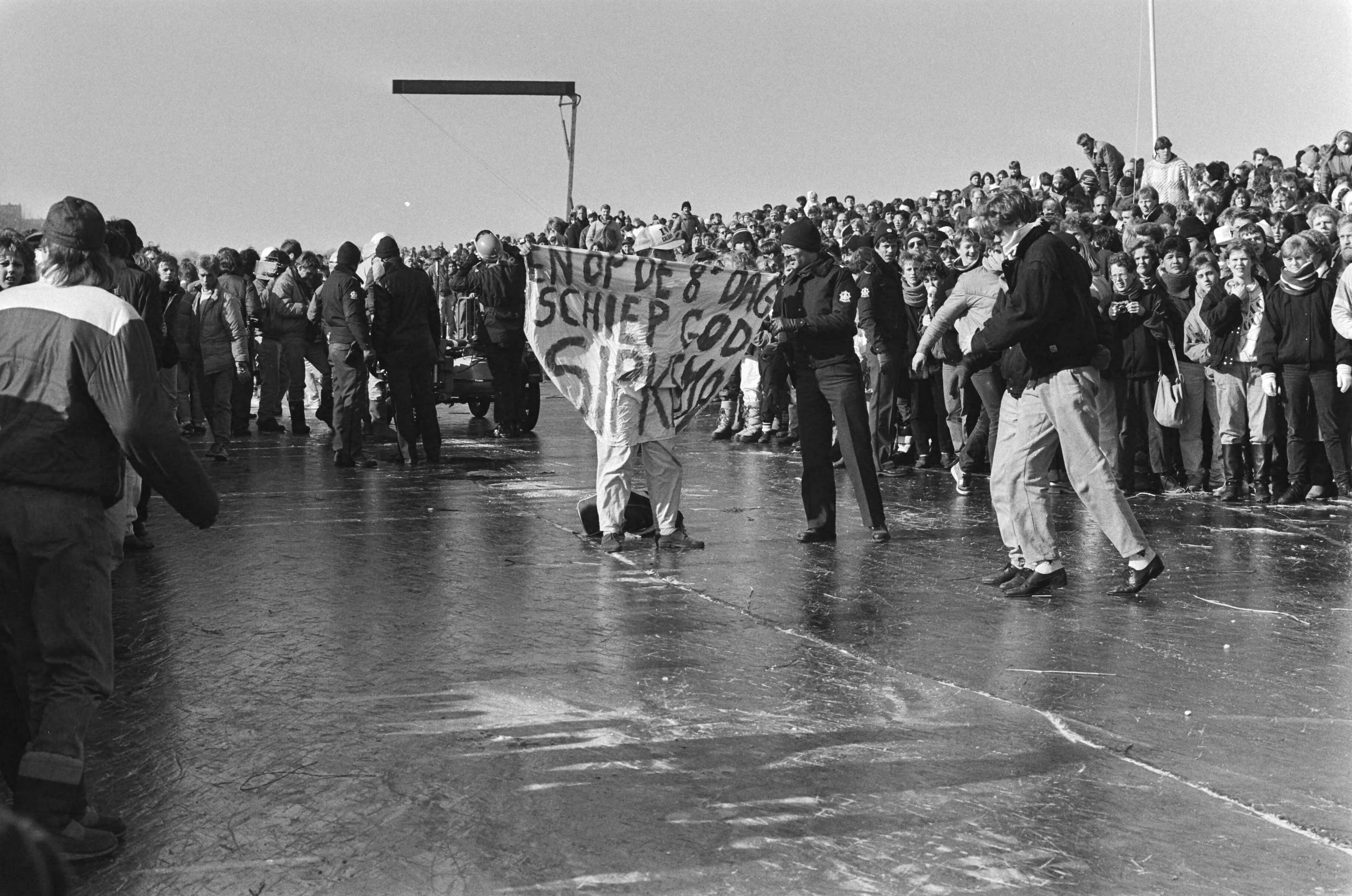 Elfstedentocht 1986 — Sipkema-aanbidder moet in Leeuwarden van het ijs — Foto: Croes, Rob C. / Anefo. Licentie: Set B: Rechtenvrij / Publiek Domein. Bron: Nationaal Archief. http://hdl.handle.net/10648/ad504fdc-d0b4-102d-bcf8-003048976d84
