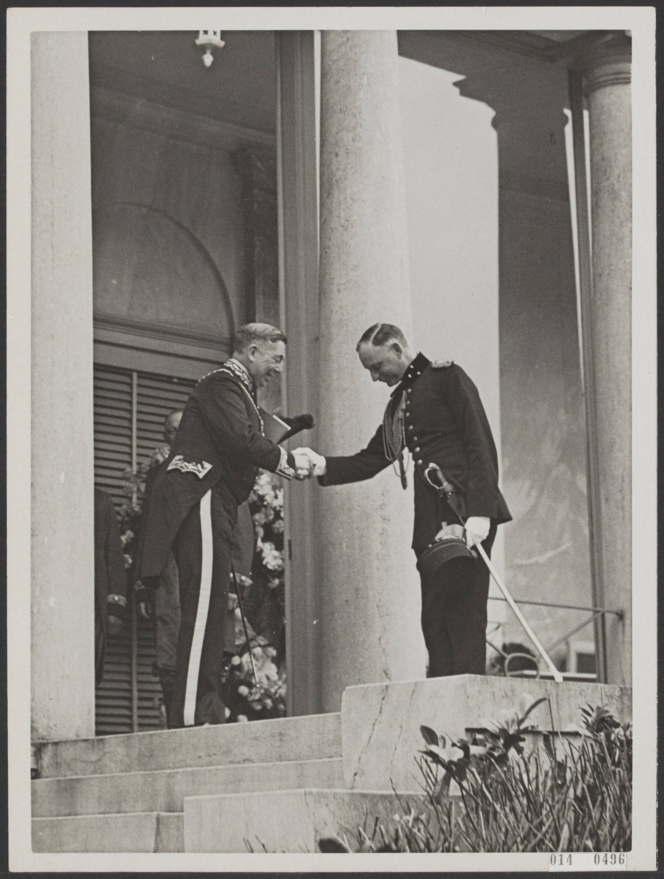 Fotocollectie Elsevier Binnenland — Aangifte van de geboorte van prinses Irene op paleis Soestdijk. De burgemeester Baarn, jhr. mr. G.C.J. van Reenen die als ambtenaar van de burgerlijke stand fungeerde verlaat het paleis, uitgeleide gedaan door de adjudant van de prins, kapitein J.K.H. de Roo van Alderwerelt (rechts) — Foto: N.V. Polygoon. Licentie: Set B: Rechtenvrij / Publiek Domein. Bron: Nationaal Archief. http://hdl.handle.net/10648/adb0d05a-d0b4-102d-bcf8-003048976d84