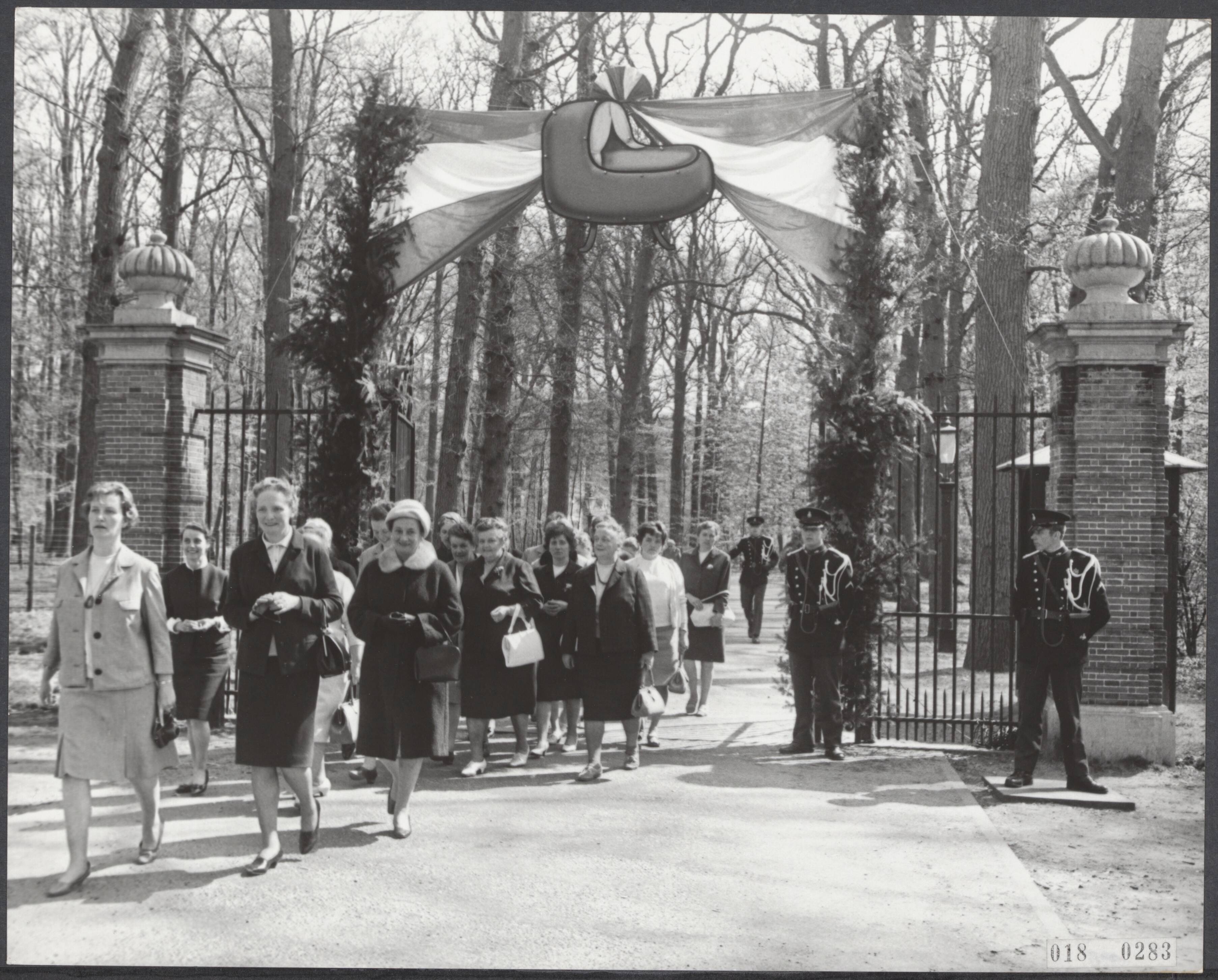 Fotocollectie Elsevier Binnenland — Na de geboorte van de baby [prins Willlem-Alexander] van prinses Beatrix en prins Claus worden op kasteel Drakensteyn doorlopend geschenken aangeboden. Na de aanbieding verlaten de mensen het kasteel door de met vlaggen versierde poort. Boven de ingang heeft men feestelijk een wieg geplaatst — Foto: Fotograaf Onbekend / Anefo. Licentie: Set B: Rechtenvrij / Publiek Domein. Bron: Nationaal Archief. http://hdl.handle.net/10648/adc1c8c4-d0b4-102d-bcf8-003048976d84
