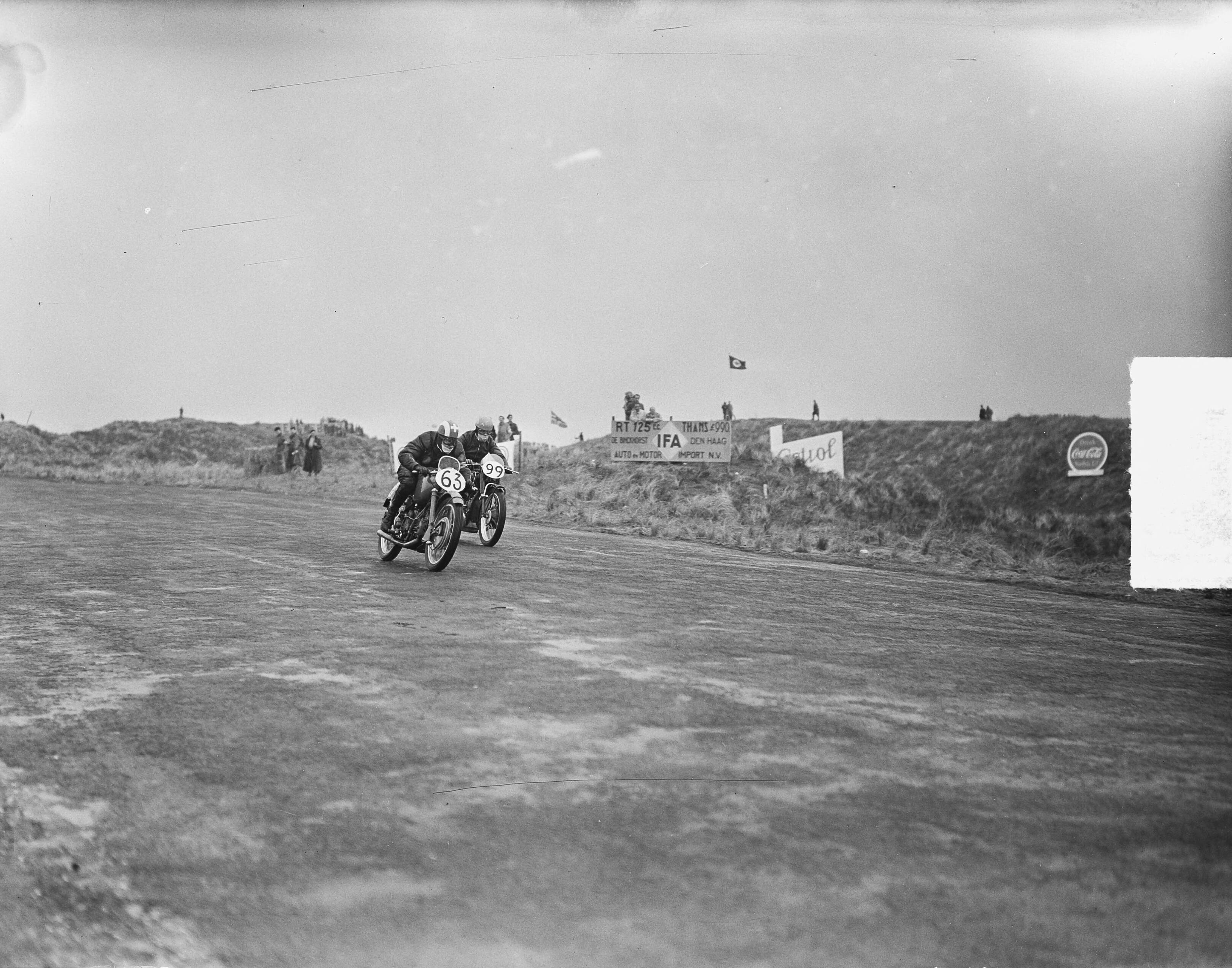 Fotocollectie Anefo — Internationale Motorraces te Zandvoort. Piet Knijnenburg (99) en de Zwitser B. Musy (63) — Foto: Bilsen, Joop van / Anefo. Licentie: Set B: Rechtenvrij / Publiek Domein. Bron: Nationaal Archief. http://hdl.handle.net/10648/a8e9a880-d0b4-102d-bcf8-003048976d84