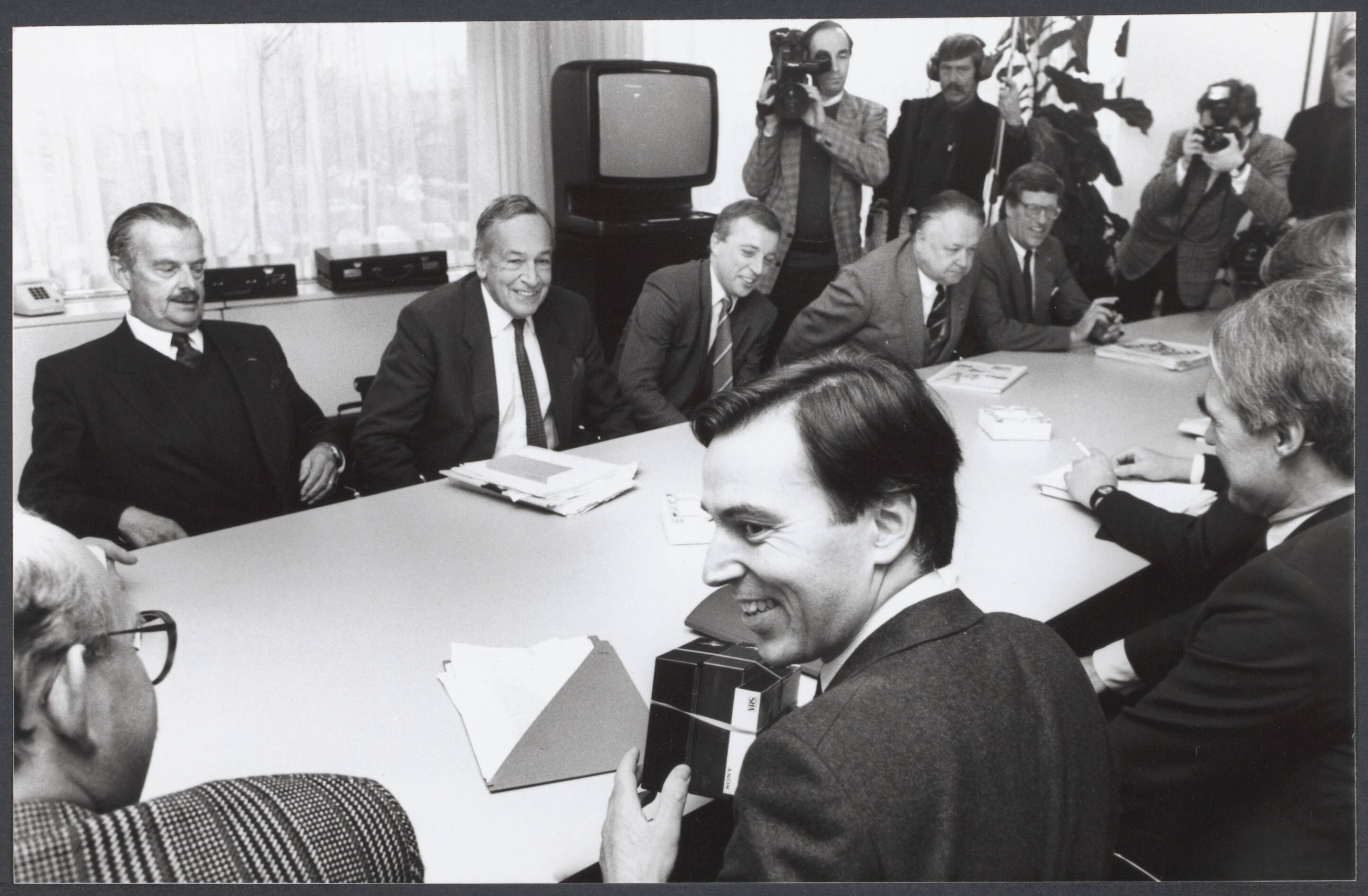 Radioraad, radio- en televisiepolitiek — In Rijswijk hebben vertegenwoordigers van de ATV-omroepen en uitgevers vanmiddag overleg gevoerd met de minsiters Brinkman en De Korte over de commerciële televisie. Tegenover de ministers Brinkman (l.) en De Korte (r.). V.l.n.r. Bordewijk (voorzitter Veronica), Minderop (voorzitter TROS) een woordvoerder reclame t.v. Lindemans (namens AVRO) en Van Aken (Telegraaf) — Foto: Croes, Rob C. / Anefo. Licentie: Set B: Rechtenvrij / Publiek Domein. Bron: Nationaal Archief. http://hdl.handle.net/10648/d83d7cb9-8391-74f2-7970-3c96a9b05da2