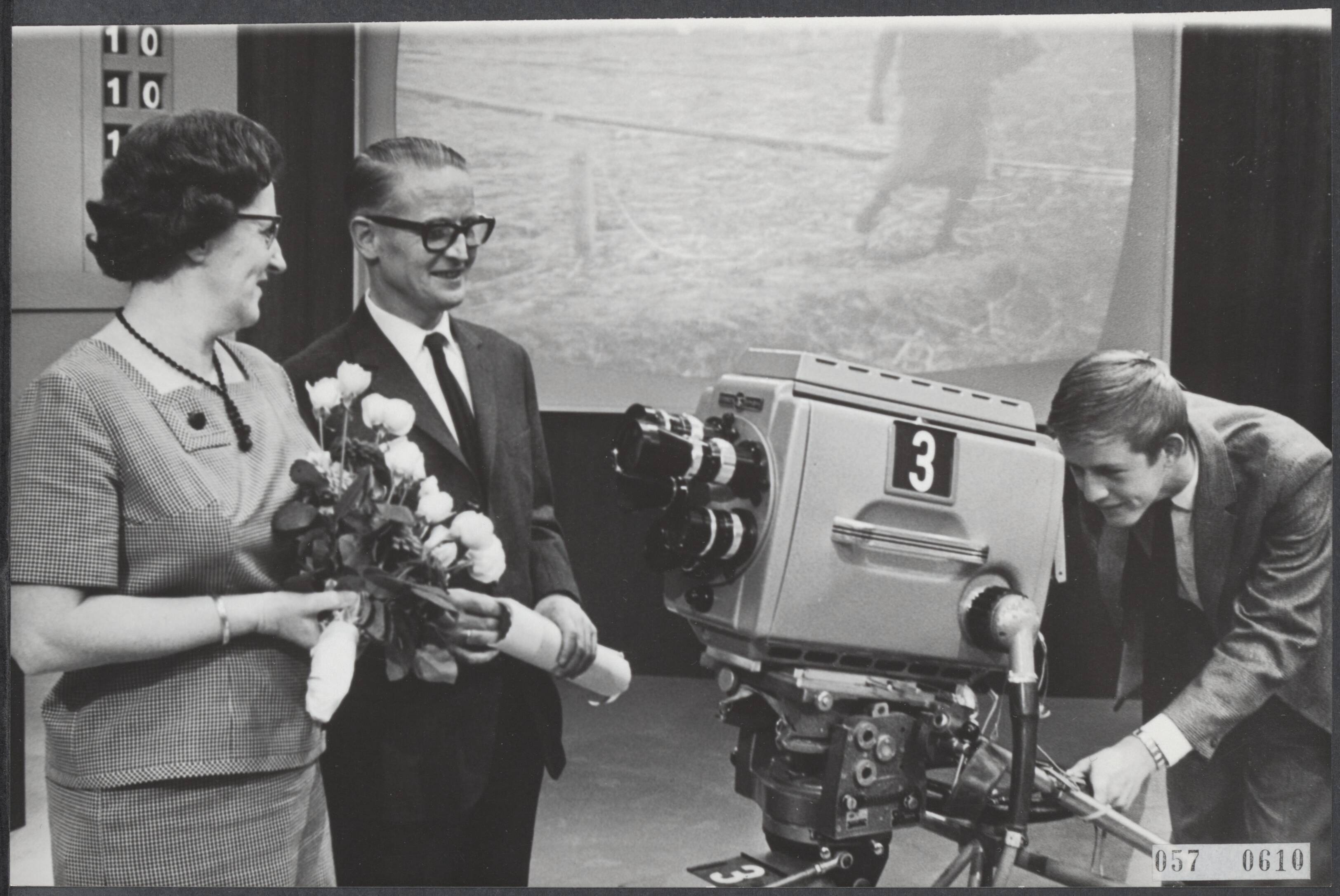 Fotocollectie Elsevier Binnenland — Twee miljoenste TV-toestel geregistreerd door de PTT. De familie Bouterse waren te gast in Studio A in Hilversum. Zoon Hans keek door de zoeker van een tv-camera naar zijn ouders — Foto: Evers, Joost / Anefo. Licentie: Set B: Rechtenvrij / Publiek Domein. Bron: Nationaal Archief. http://hdl.handle.net/10648/ae0a0580-d0b4-102d-bcf8-003048976d84