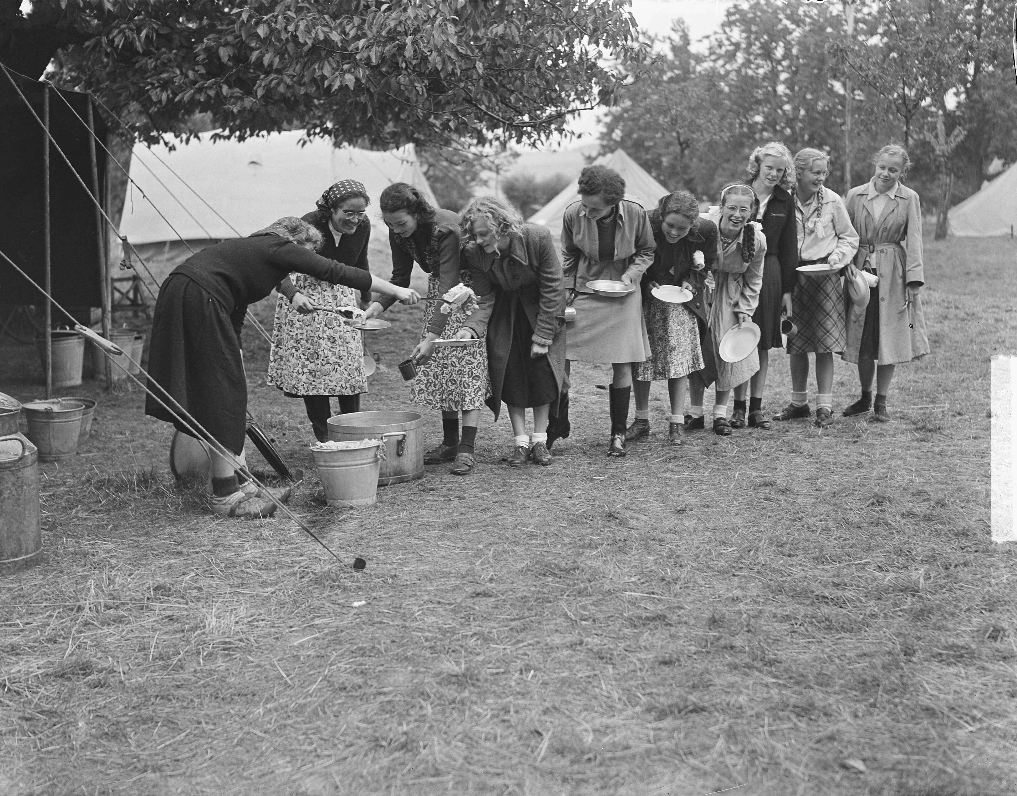 Fotocollectie Anefo — Kamp Mheer. Meisjes halen eten — Foto: Oorschot, […] van / Anefo. Licentie: Set B: Rechtenvrij / Publiek Domein. Bron: Nationaal Archief. http://hdl.handle.net/10648/a8cc42b8-d0b4-102d-bcf8-003048976d84