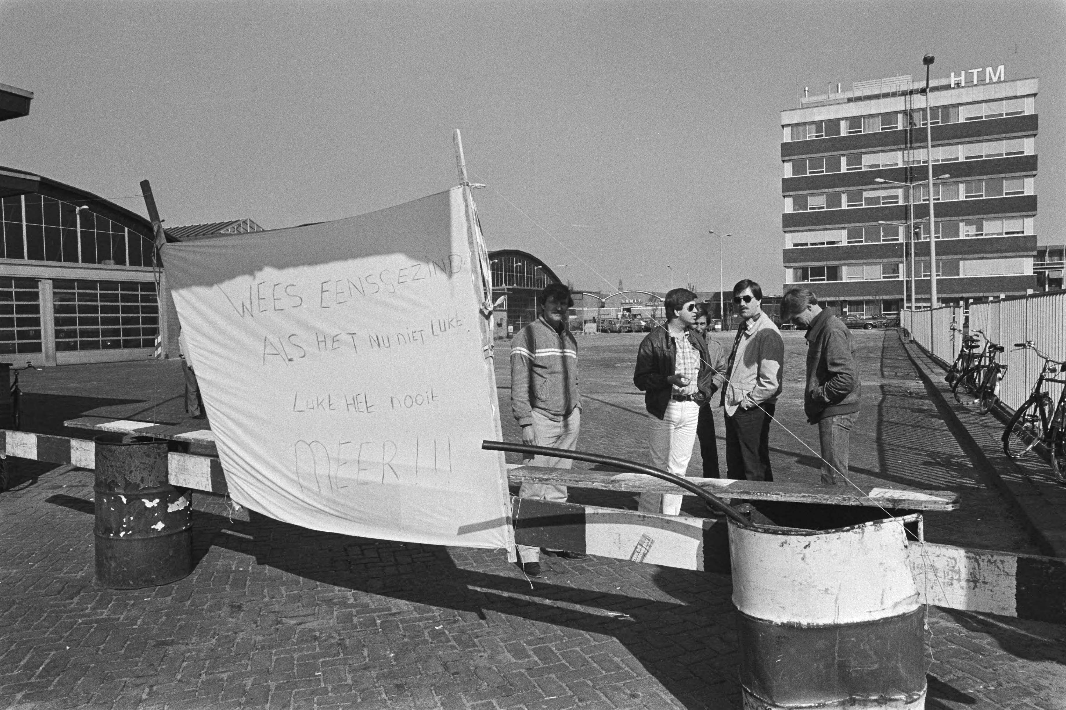 Fotocollectie Anefo — Staking HTM in Den Haag duurt voort, stakende buschauffeurs bij spandoek voor de busgarages — Foto: Dijk, Hans van / Anefo. Licentie: Set B: Rechtenvrij / Publiek Domein. Bron: Nationaal Archief. http://hdl.handle.net/10648/acfbee2e-d0b4-102d-bcf8-003048976d84