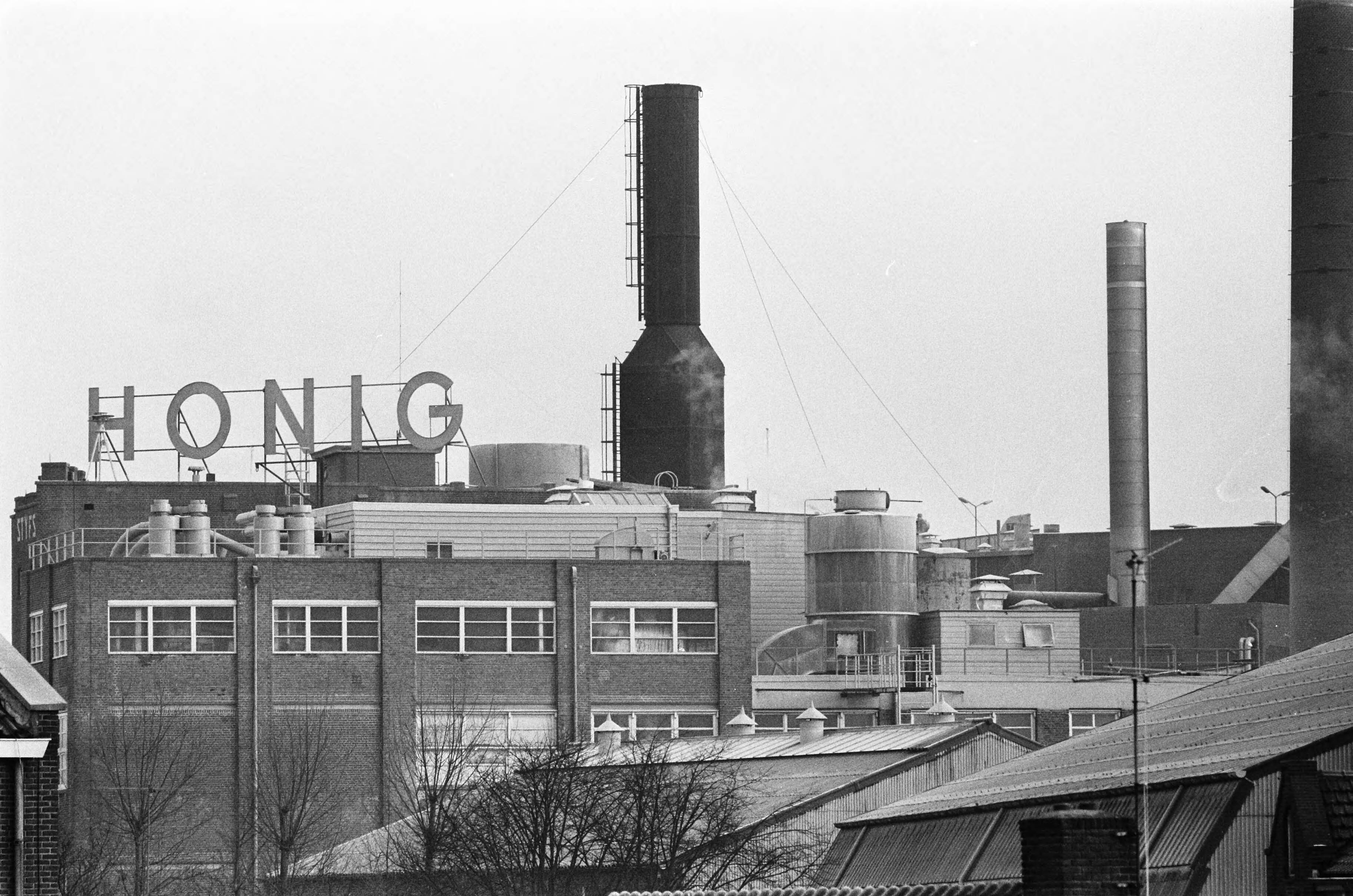 Fotocollectie Anefo — Werknemers van Honig in Koog aan de Zaan staken voor 1% duurtetoeslag en werktijdverkorting aan eind van de dag. Exterieur opschrift "Honig" — Foto: Evers, Joost / Anefo. Licentie: Set B: Rechtenvrij / Publiek Domein. Bron: Nationaal Archief. http://hdl.handle.net/10648/ab86436e-d0b4-102d-bcf8-003048976d84