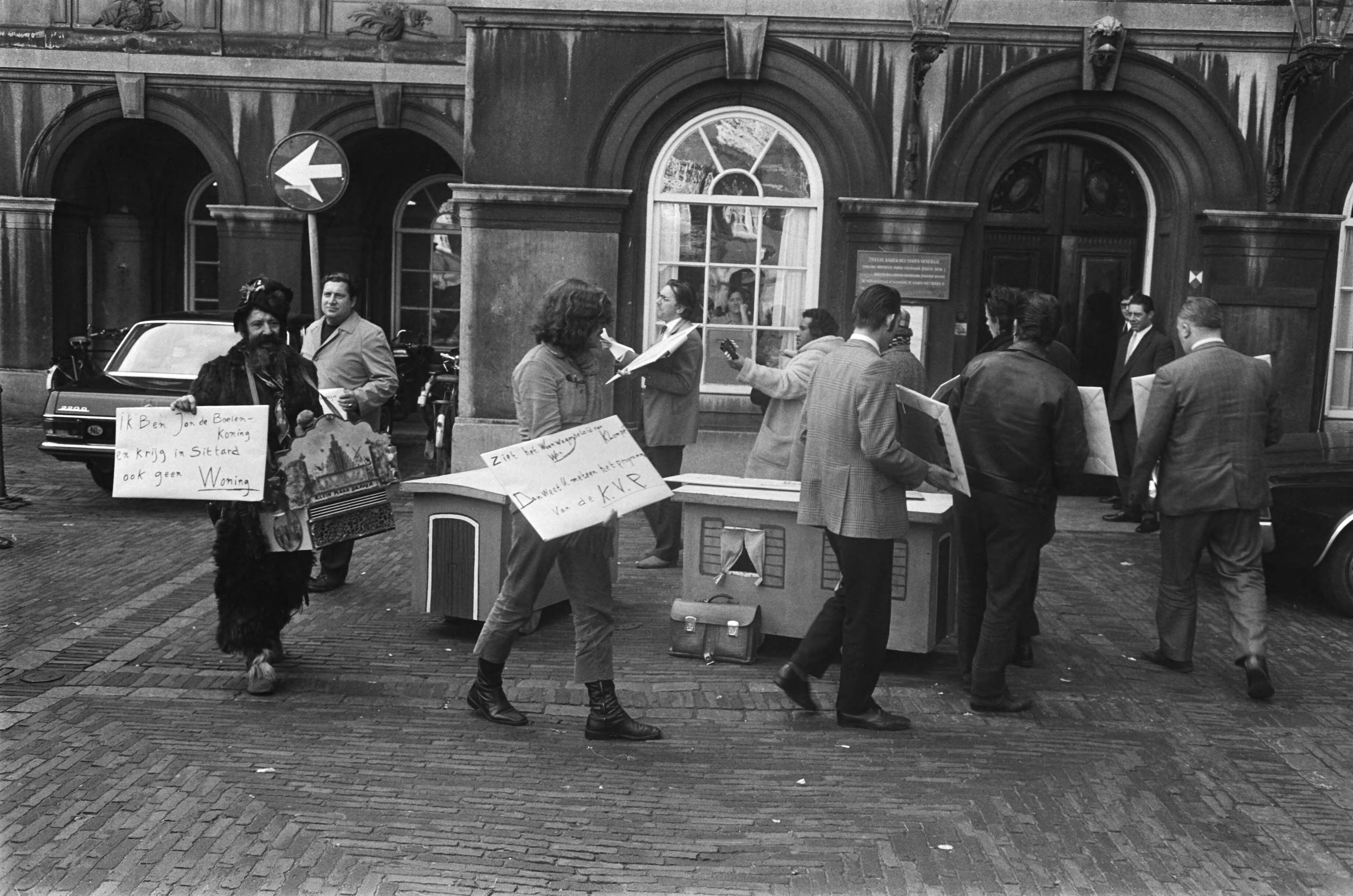 Protestdemonstratie op het Binnenhof in Den Haag tegen het woonwagenbeleid — Demonstranten protesteren met kartonnen mini-woonwagens en borden — Foto: Fotograaf Onbekend / Anefo. Licentie: Set B: Rechtenvrij / Publiek Domein. Bron: Nationaal Archief. http://hdl.handle.net/10648/abb75c6a-d0b4-102d-bcf8-003048976d84