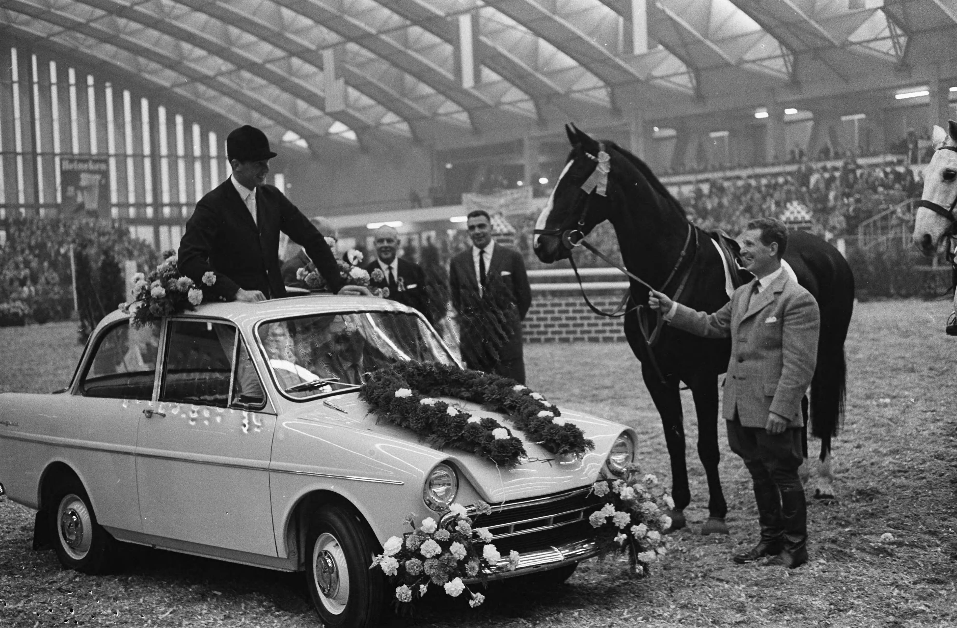 Fotocollectie Anefo — Jumping Amsterdam, jachtspringconcours om de Grote Prijs van Nederland, winnaar Tommy Brennan (Ierland) in een DAF Daffodil (de extra prijs), rechts zijn springpaard Killrush — Foto: Pot, Harry / Anefo. Licentie: Set B: Rechtenvrij / Publiek Domein. Bron: Nationaal Archief. http://hdl.handle.net/10648/aa1d1700-d0b4-102d-bcf8-003048976d84