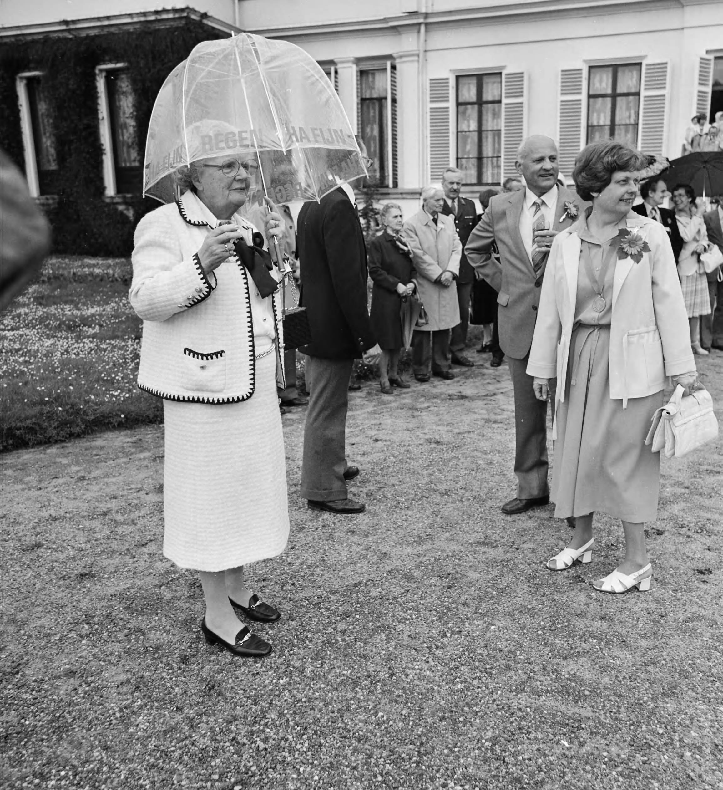 HM ontvangt deputaties van de Christelijke Oranjevereniging Nederland i.v.m. hun bondsdag — koningin Juliana met glaasje onder paraplu — Foto: Croes, Rob C. / Anefo. Licentie: Set B: Rechtenvrij / Publiek Domein. Bron: Nationaal Archief. http://hdl.handle.net/10648/accac3d0-d0b4-102d-bcf8-003048976d84