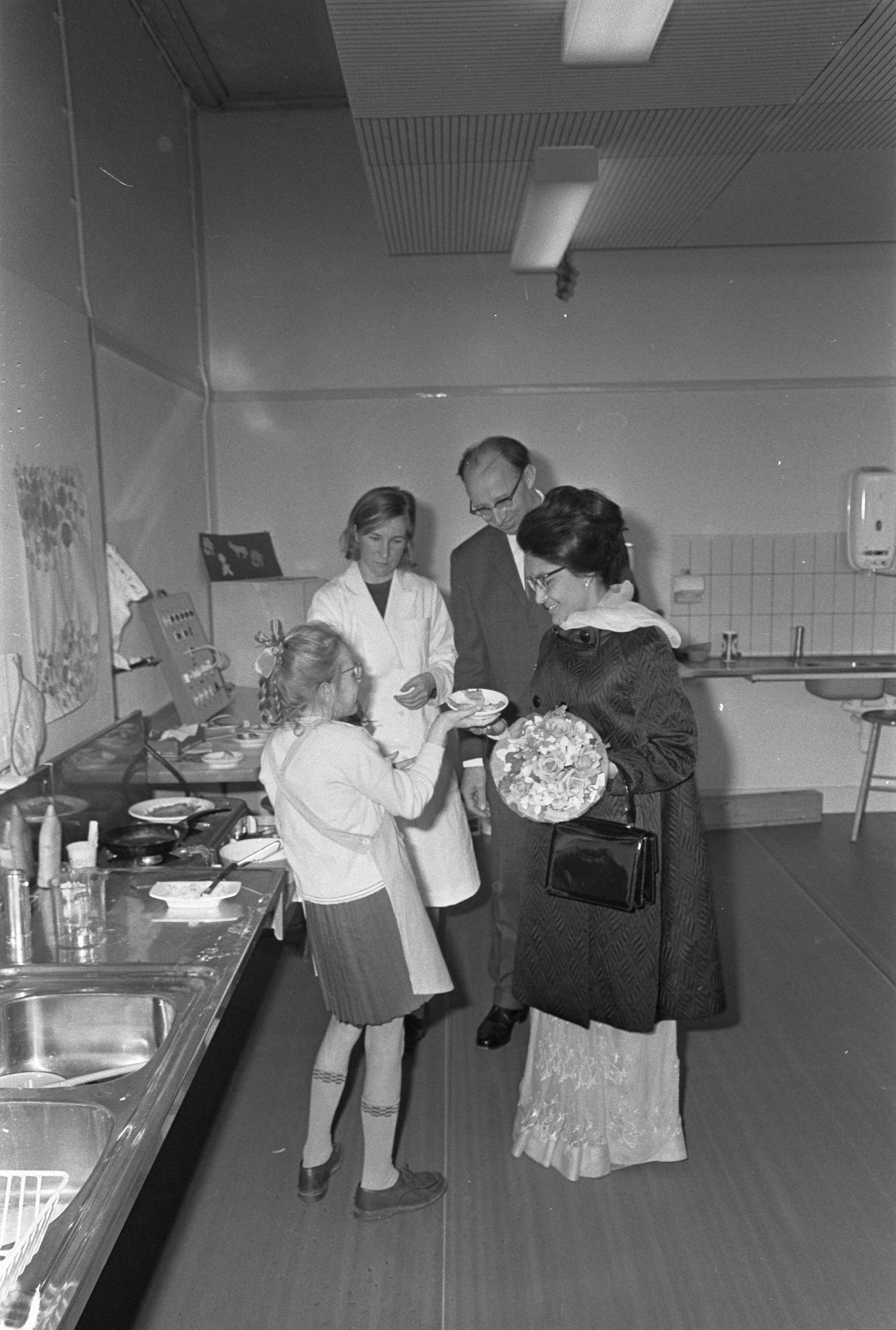 Fotocollectie Anefo — Bezoek Koning en Koningin van Nepal aan Den Haag , Koningin Nepal bezocht Mytylschool, krijgt stukje panneko van meisje — Foto: Nijs, Jac. de / Anefo. Licentie: Set B: Rechtenvrij / Publiek Domein. Bron: Nationaal Archief. http://hdl.handle.net/10648/ab16f126-d0b4-102d-bcf8-003048976d84