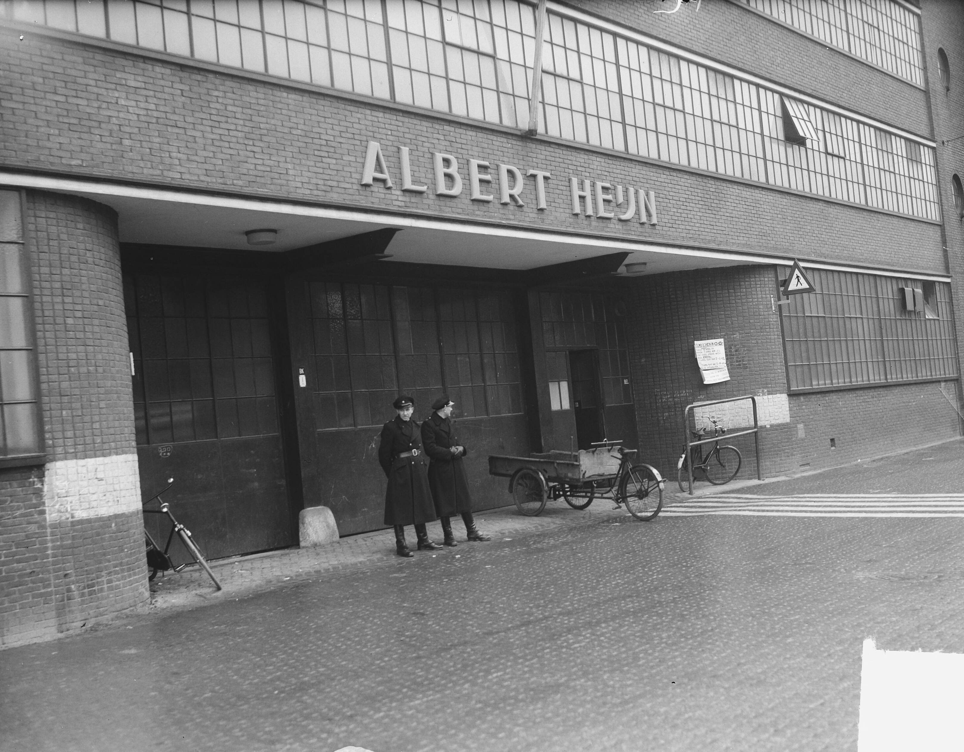 Fotocollectie Anefo — Staking Albert Heijn Zaandam. Politie bij de poort — Foto: Vogel, Carel L. de / Anefo. Licentie: Set B: Rechtenvrij / Publiek Domein. Bron: Nationaal Archief. http://hdl.handle.net/10648/a8e85e94-d0b4-102d-bcf8-003048976d84