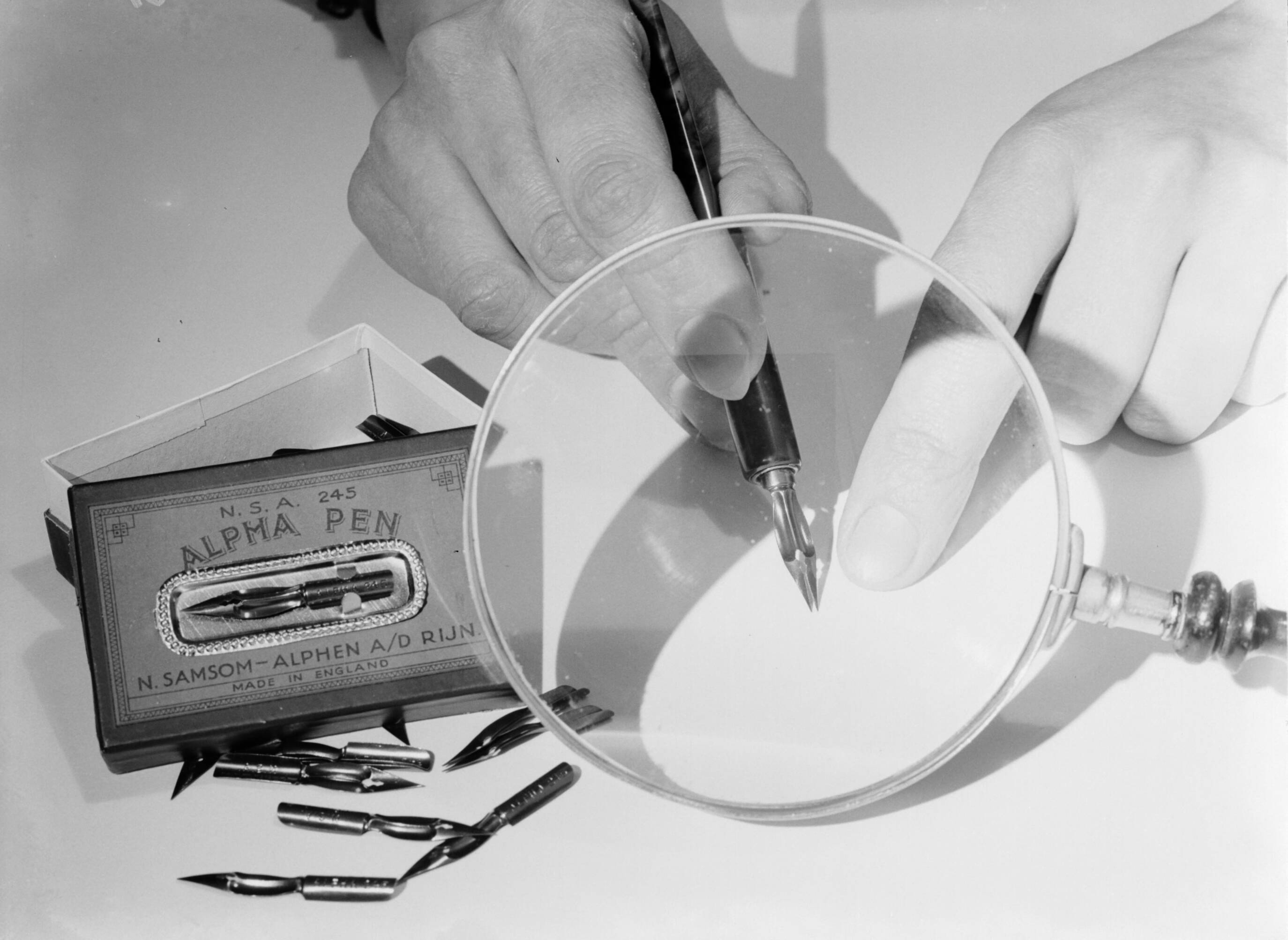 Reclamefotografie — Alpha-pen onder een loep — Foto: Poll, Willem van de. Licentie: Set B: Rechtenvrij / Publiek Domein. Bron: Nationaal Archief. http://hdl.handle.net/10648/ae998a48-d0b4-102d-bcf8-003048976d84
