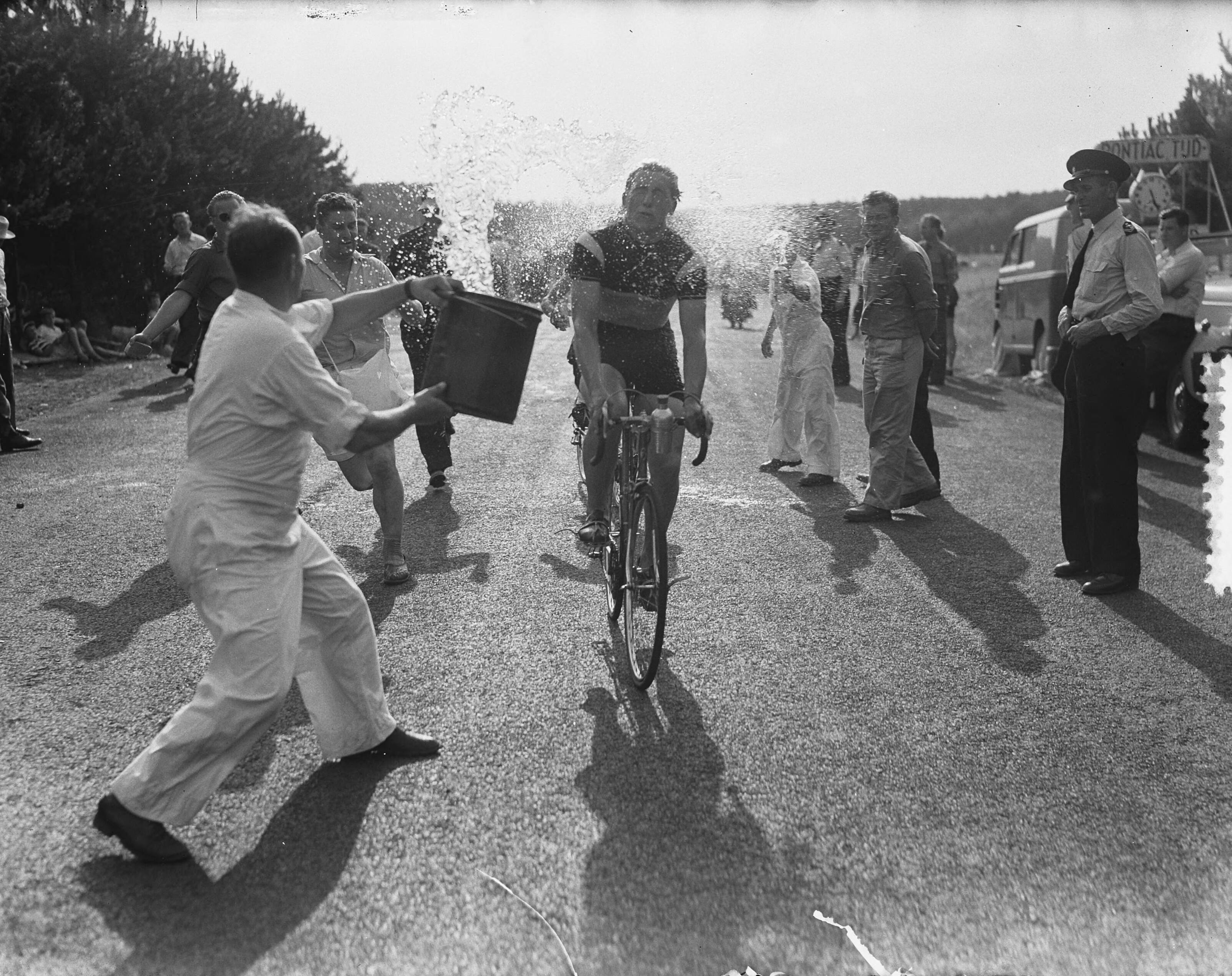 Nederlandse kampioenschap wegwedstrijd wielrennen voor amateurs (1952) — Nederlands kampioenschap wielrennen op de weg voor amateurs op het circuit van Zandvoort. Een renner krijgt water over zich heen gegooid — Foto: Noske, J.D. / Anefo. Licentie: Set B: Rechtenvrij / Publiek Domein. Bron: Nationaal Archief. http://hdl.handle.net/10648/a8fc9a30-d0b4-102d-bcf8-003048976d84