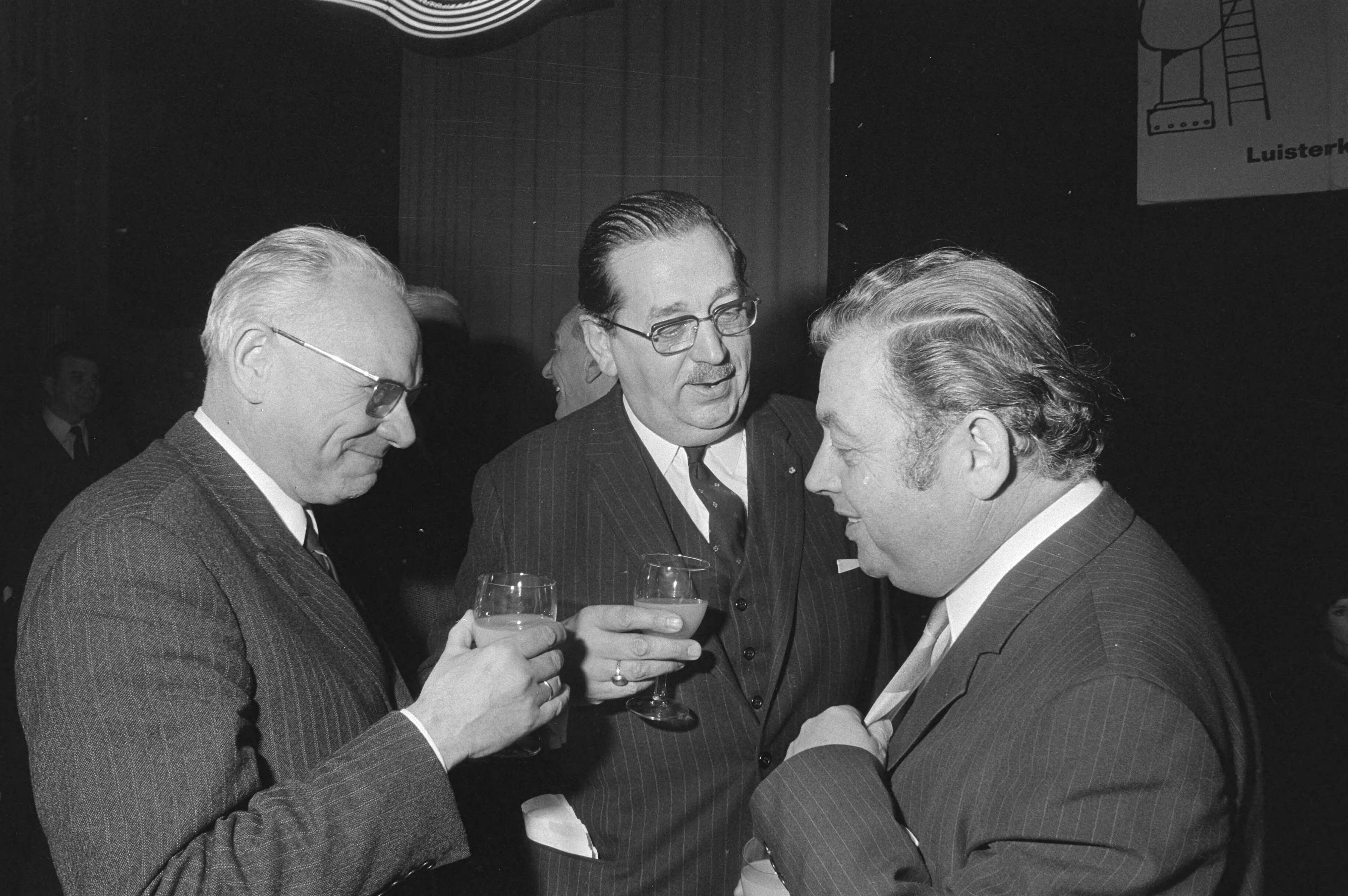 Fotocollectie Anefo — Nieuwjaarsreceptie NOS, Hilversum; v.l.n.r. Rengelink, voorzitter Schuttenhelm, Enkelaar — Foto: Mieremet, Rob / Anefo. Licentie: Set B: Rechtenvrij / Publiek Domein. Bron: Nationaal Archief. http://hdl.handle.net/10648/abaef660-d0b4-102d-bcf8-003048976d84