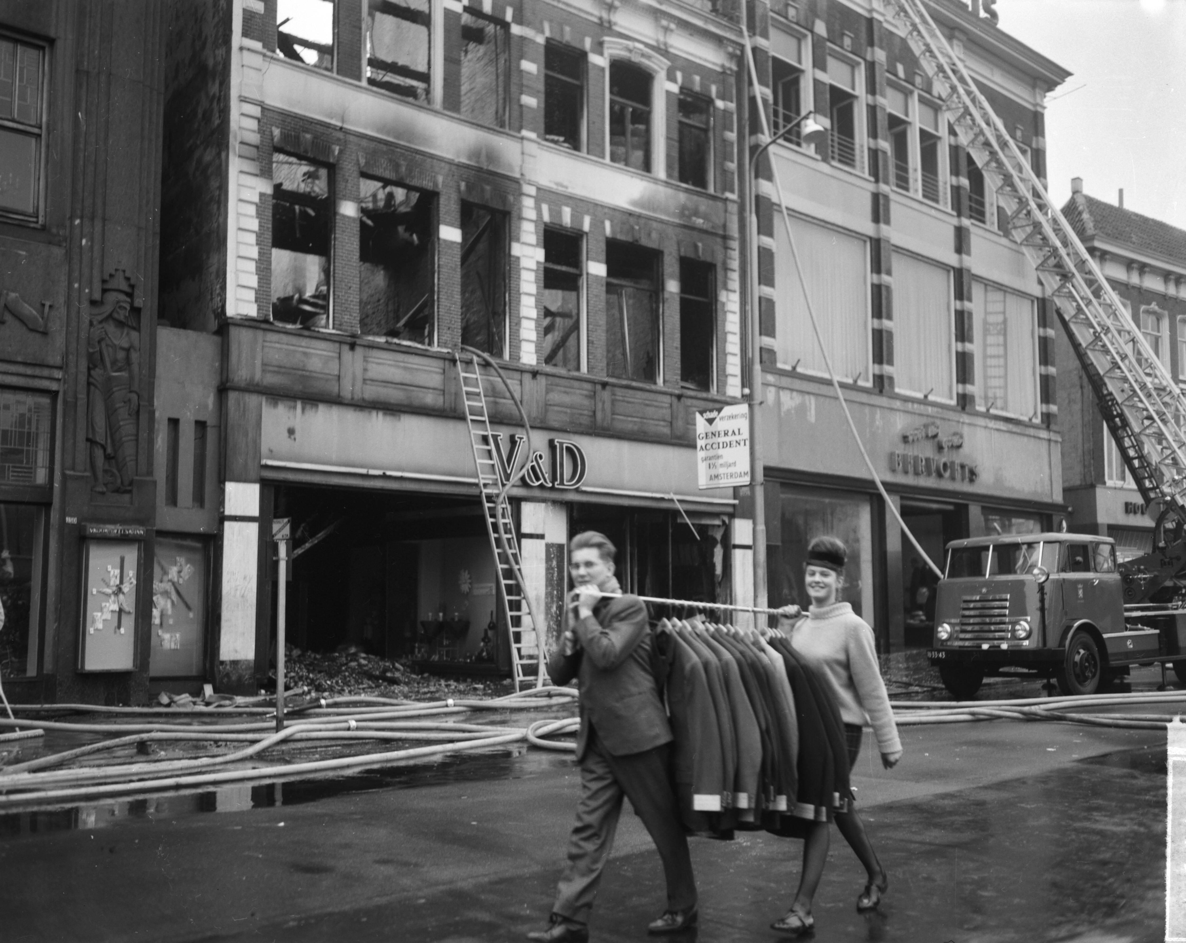 Fotocollectie Anefo — Brand bij V&D te Leeuwarden. Onbeschadigde confectie wordt in veiligheid gebracht — Foto: Bilsen, Joop van / Anefo. Licentie: Set B: Rechtenvrij / Publiek Domein. Bron: Nationaal Archief. http://hdl.handle.net/10648/aa2ed71a-d0b4-102d-bcf8-003048976d84