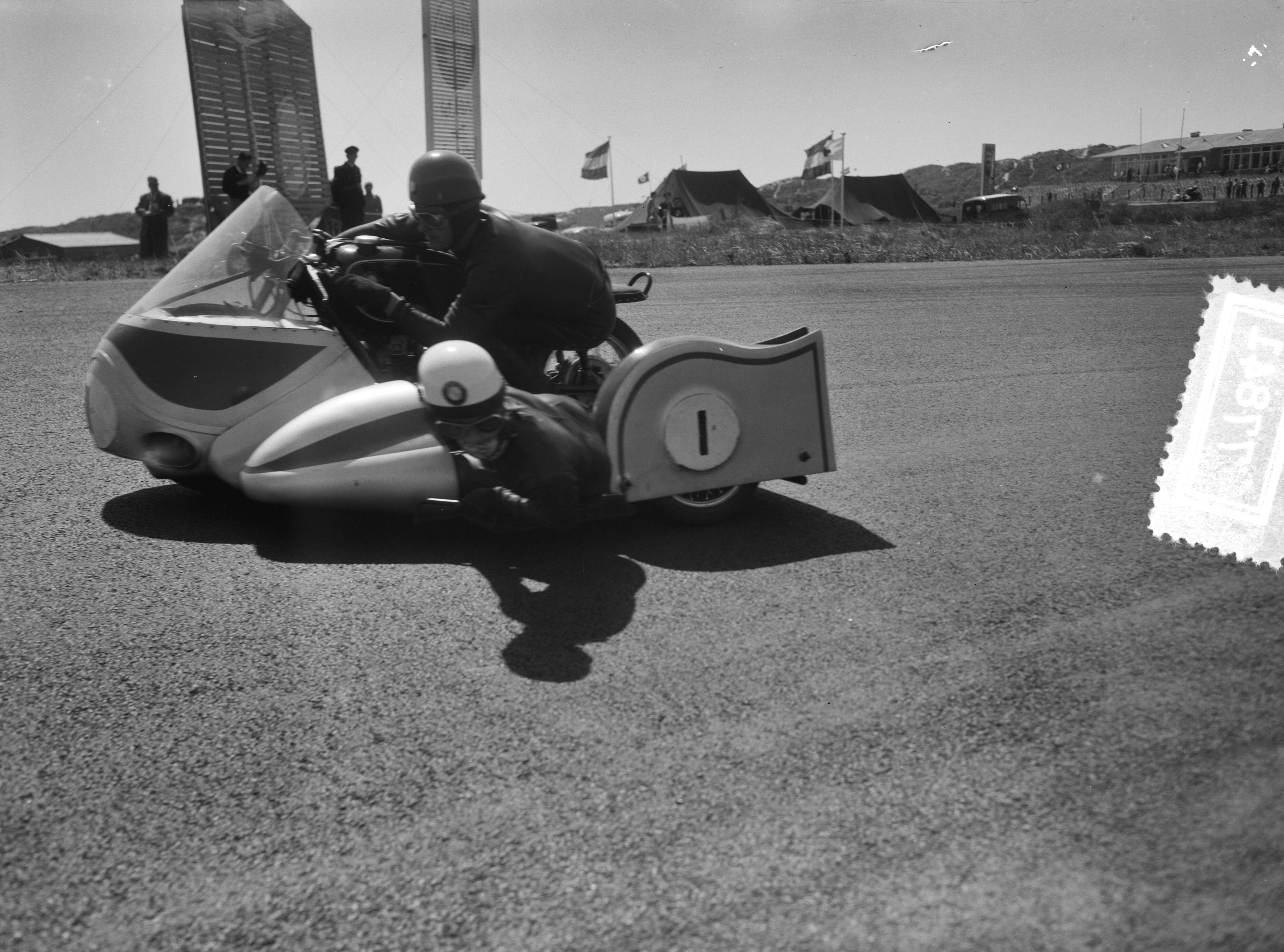 Fotocollectie Anefo — Zijspanrace op het circuit van Zandvoort. Jacques Drion (met bakkeniste Ingeborg Stoll) (Frankrijk/Duitsland) — Foto: Bilsen, Joop van / Anefo. Licentie: Set B: Rechtenvrij / Publiek Domein. Bron: Nationaal Archief. http://hdl.handle.net/10648/a948a2b8-d0b4-102d-bcf8-003048976d84