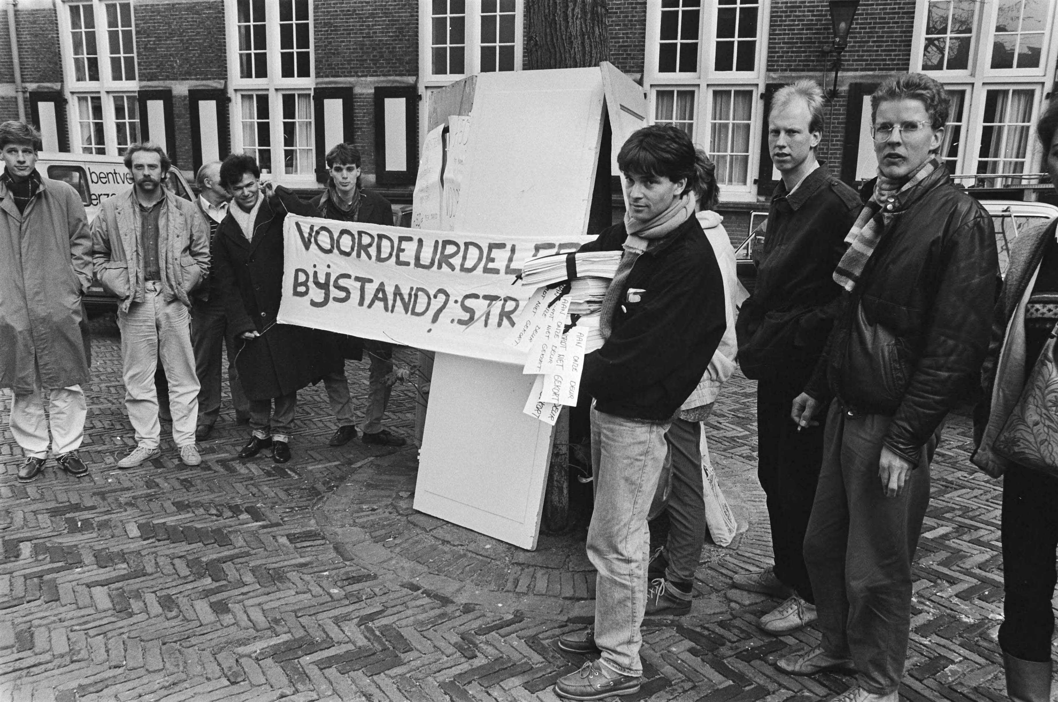 Fotocollectie Anefo — Protesten in Den Haag tegen z.g. "voordeurdelersnorm" jongeren waren met voordeuren en handtekeningen naar het Binnenhof gekomen — Foto: Croes, Rob C. / Anefo. Licentie: Set B: Rechtenvrij / Publiek Domein. Bron: Nationaal Archief. http://hdl.handle.net/10648/ad3fc39c-d0b4-102d-bcf8-003048976d84