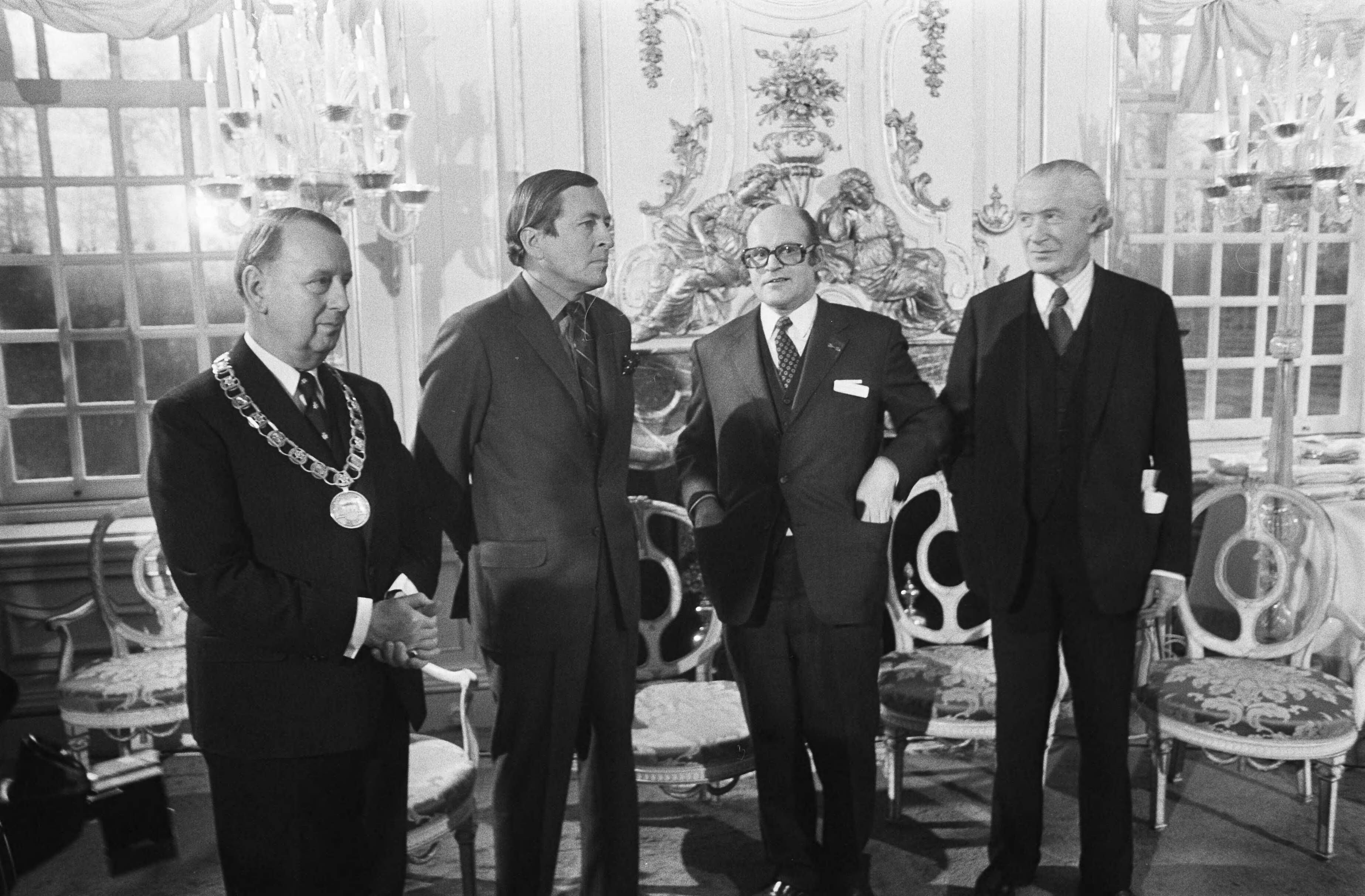 Fotocollectie Anefo — In functie van erevoorzitter Nationaal Comité Monumentenjaar 1975 overhandigde Prins Claus aan de burgemeesters van tien gemeenten de nieuw ontworpen Monumentenvlag in Slot van Zeist. Links van de prins burgemeester Stolk, rechts van de prins drs. F.H.M. Grapperhaus, voorzitter van het Nationaal Comité Monumentenjaar 1975, en uiterst rechts lord Duncan Sandys, de initiatiefnemer tot het Monumentenjaar. — Foto: Peters, Hans / Anefo. Licentie: Set B: Rechtenvrij / Publiek Domein. Bron: Nationaal Archief. http://hdl.handle.net/10648/ac5d63e4-d0b4-102d-bcf8-003048976d84