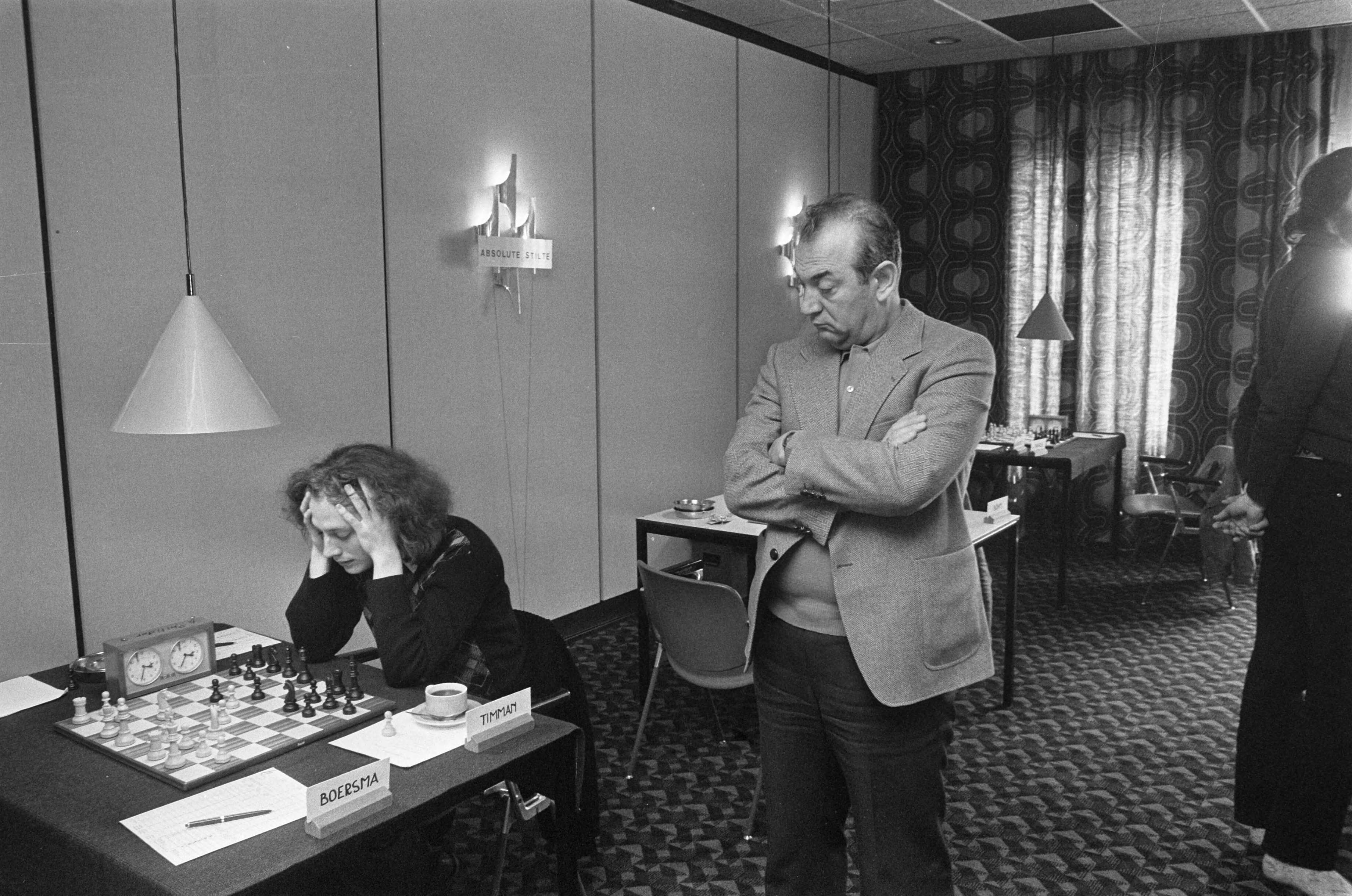 De Nederlandse kampioenschappen schaken 1977 — Viktor Kortsnoj kijkt mee bij Jan Timmans partij tegen Paul Boersma — Foto: Bogaerts, Rob / Anefo. Licentie: Set B: Rechtenvrij / Publiek Domein. Bron: Nationaal Archief. http://hdl.handle.net/10648/ac9a0e70-d0b4-102d-bcf8-003048976d84