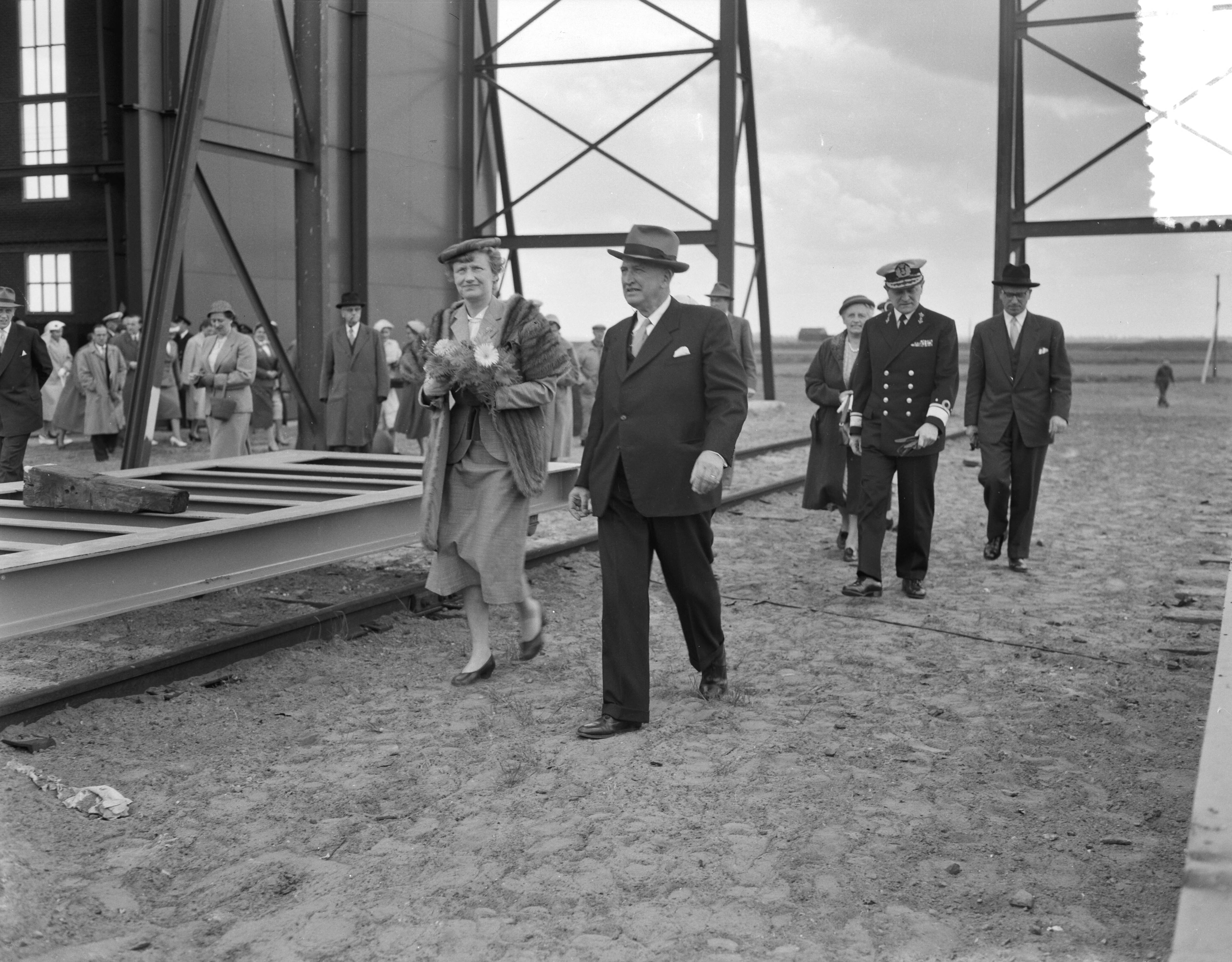 Fotocollectie Anefo — Tewaterlating van de mijnenveger Hr. Ms. "Lisse" bij scheepswerf E.J. Smit & Zn. te Westerbroek. De doopplechtigheid werd verricht door de echtgenote van de burgemeester van Lisse, mevr. W.H.M. de Graaf-Theuling. Haar man Theo de Graaf loopt in de achtergrond met donkere hoed — Foto: Rossem, Wim van / Anefo. Licentie: Set B: Rechtenvrij / Publiek Domein. Bron: Nationaal Archief. http://hdl.handle.net/10648/a948379c-d0b4-102d-bcf8-003048976d84