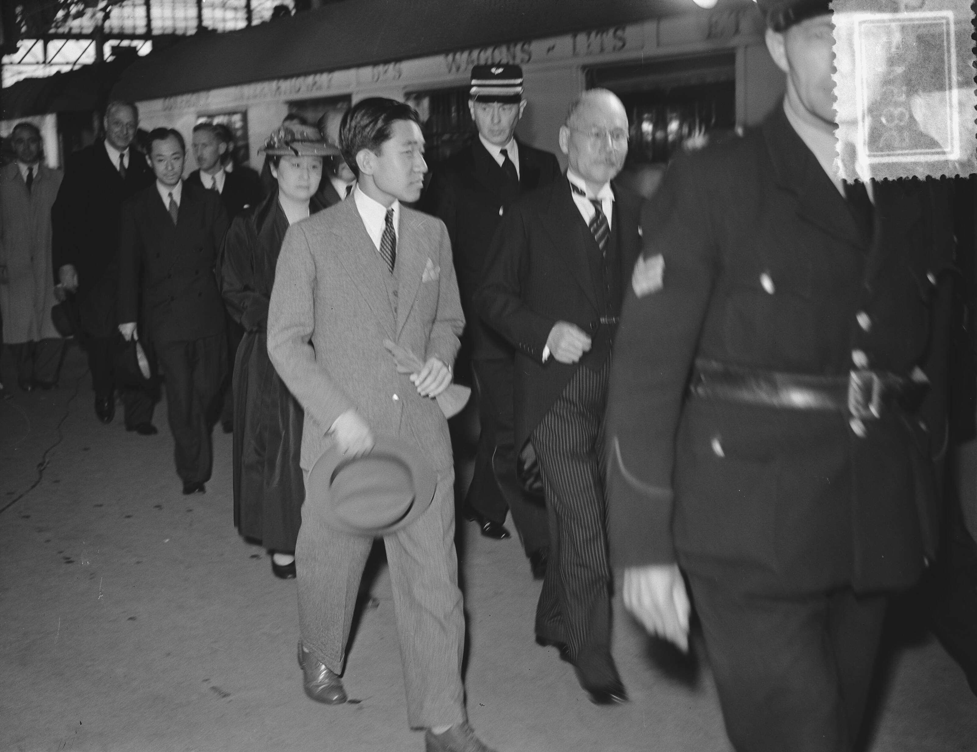 Fotocollectie Anefo — Kroonprins Akihito van Japan bezoekt Nederland. Aankomst in Den Haag. Naast hem de Japanse ambassadeur Suemasa Okamoto — Foto: Bilsen, Joop van / Anefo. Licentie: Set B: Rechtenvrij / Publiek Domein. Bron: Nationaal Archief. http://hdl.handle.net/10648/a9100c28-d0b4-102d-bcf8-003048976d84