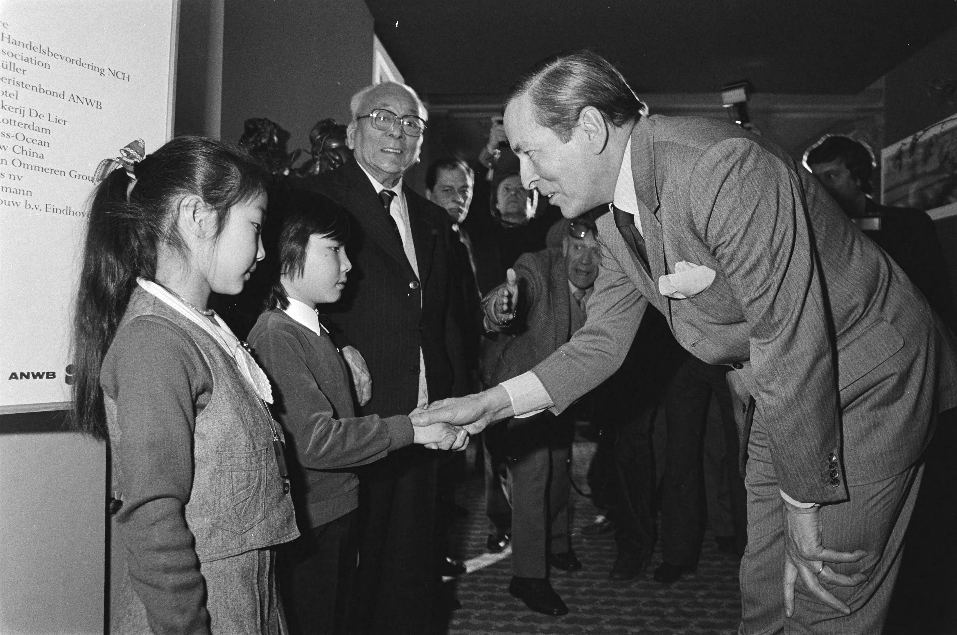 Fotocollectie Anefo — Claus woonde opening van fototent. "China Nu" in het Kurhaus te Scheveningen bij. Chinese kinderen en oudste Chinees Cheung — Foto: Antonisse, Marcel / Anefo. Licentie: Set B: Rechtenvrij / Publiek Domein. Bron: Nationaal Archief. http://hdl.handle.net/10648/ad0f9af0-d0b4-102d-bcf8-003048976d84