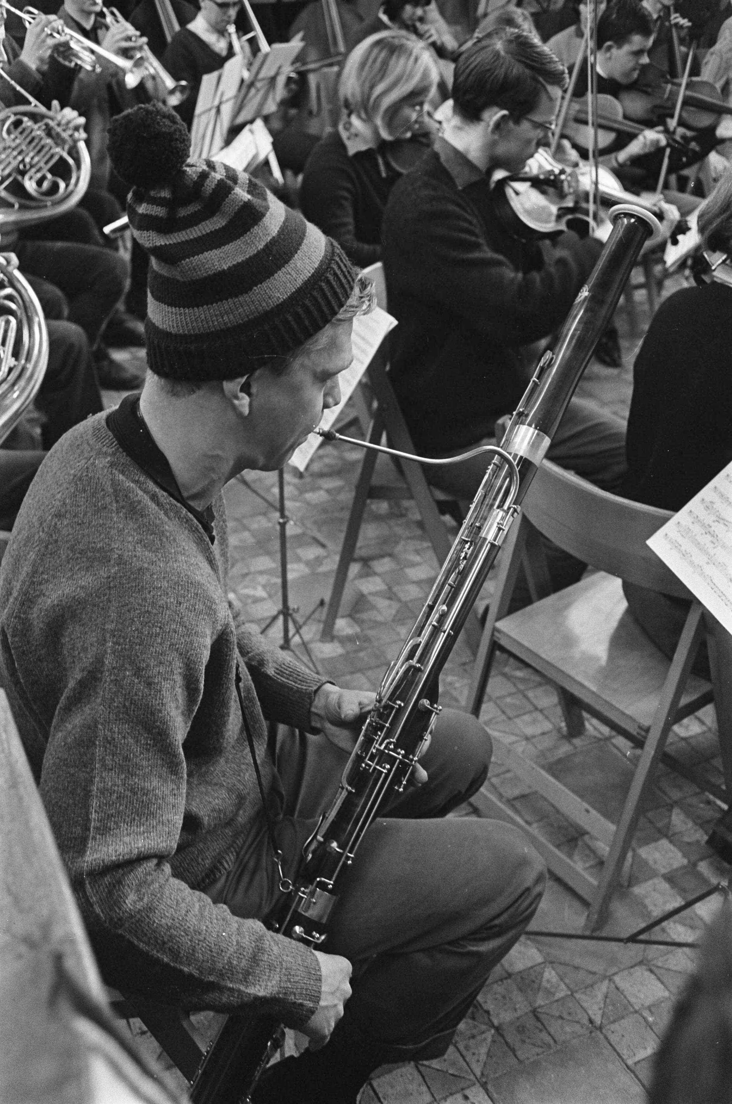 Fotocollectie Anefo — Studenten Orkest oefent in kerk van Bergen. De hoboist met ijsmuts op — Foto: Koch, Eric / Anefo. Licentie: Set B: Rechtenvrij / Publiek Domein. Bron: Nationaal Archief. http://hdl.handle.net/10648/ab31d4aa-d0b4-102d-bcf8-003048976d84