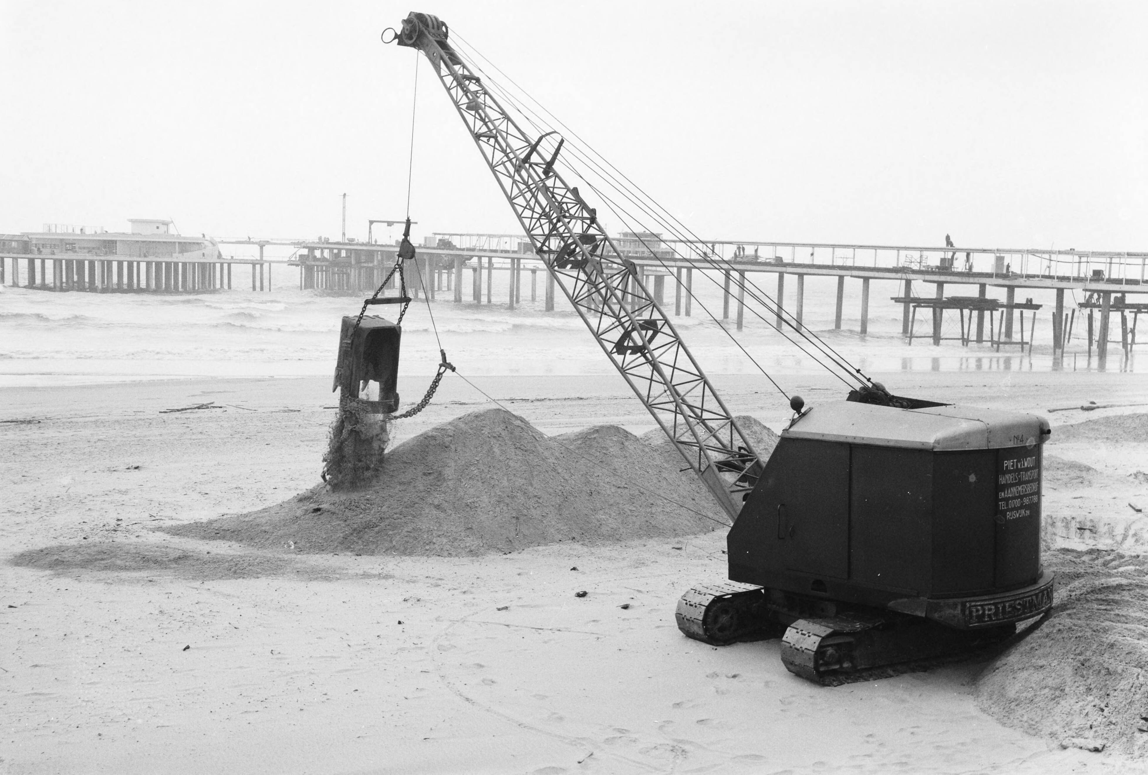 Fotocollectie Anefo — Egaliseren van het strand te Scheveningen voor het komend badseizoen — Foto: Behrens, Herbert F. / Anefo. Licentie: Set B: Rechtenvrij / Publiek Domein. Bron: Nationaal Archief. http://hdl.handle.net/10648/a9ccf07c-d0b4-102d-bcf8-003048976d84