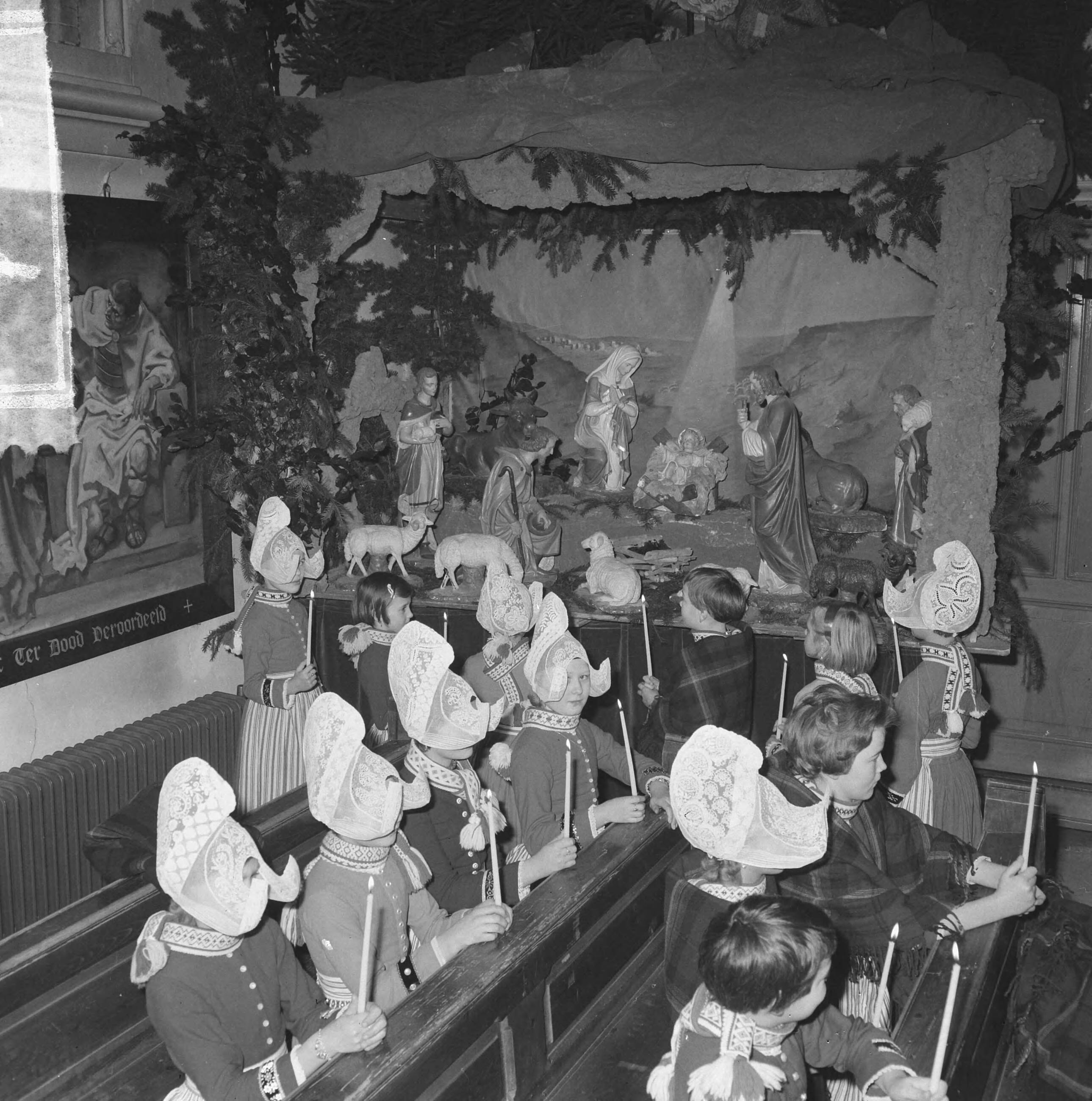 Fotocollectie Anefo — Kerstmis in Volendam, kinderen in de Vincentiuskerk kijken naar kerstkribbe — Foto: Nijs, Jac. de / Anefo. Licentie: Set B: Rechtenvrij / Publiek Domein. Bron: Nationaal Archief. http://hdl.handle.net/10648/aa89b36a-d0b4-102d-bcf8-003048976d84