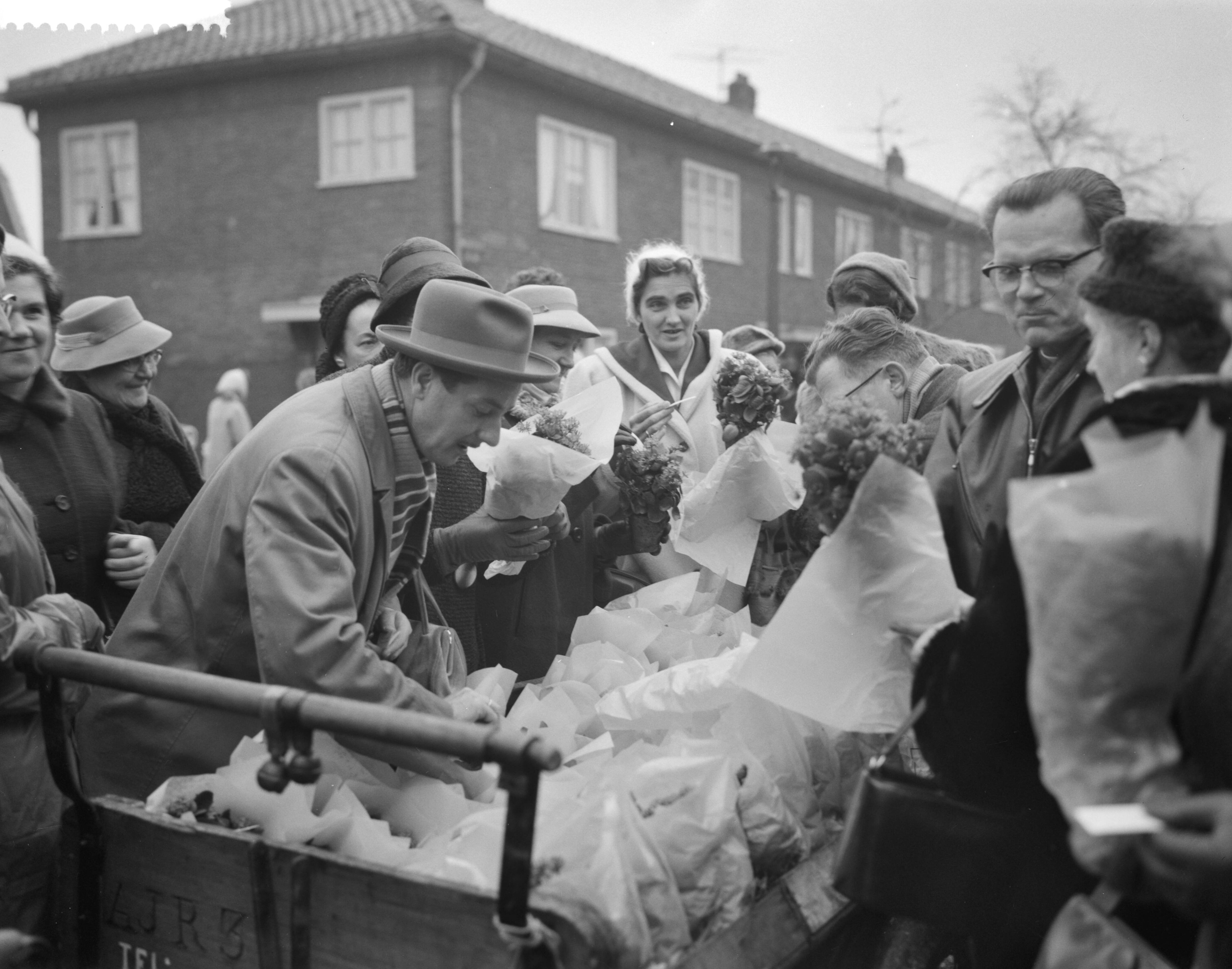 Fotocollectie Anefo — Vrouwen van Schouwen-Duiveland schenken bloemen aan Tuindorp Oostzaan. Vrouwen delen bloemen uit — Foto: Rossem, Wim van / Anefo. Licentie: Set B: Rechtenvrij / Publiek Domein. Bron: Nationaal Archief. http://hdl.handle.net/10648/a9a7eda4-d0b4-102d-bcf8-003048976d84