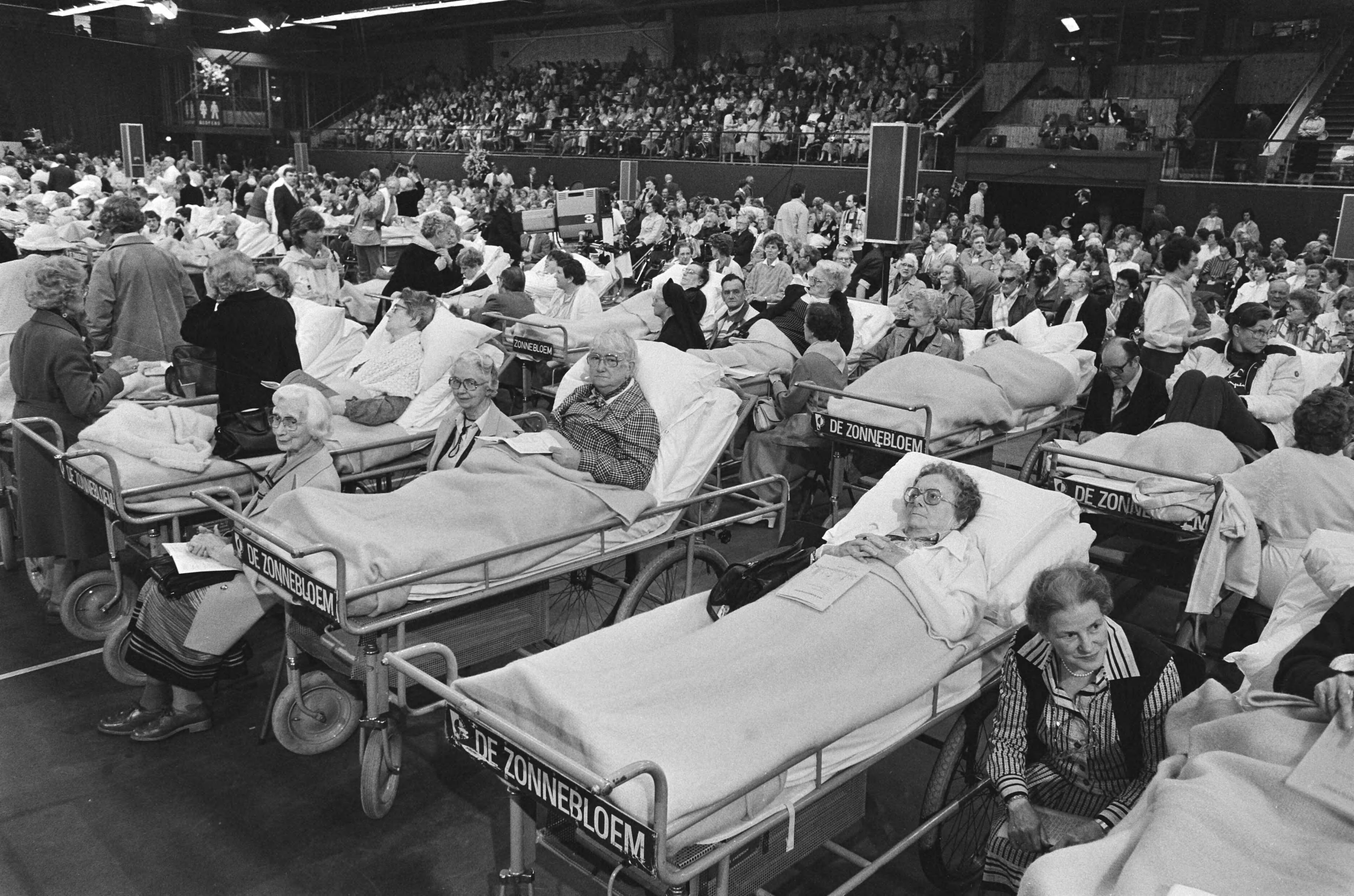 Fotocollectie Anefo — Bezoek Paus Johannes Paulus II aan Nederland; eucharistieviering in Houtrusthallen Den Haag ; overzicht zieken en gehandicapten — Foto: Croes, Rob C. / Anefo. Licentie: Set B: Rechtenvrij / Publiek Domein. Bron: Nationaal Archief. http://hdl.handle.net/10648/ad46a554-d0b4-102d-bcf8-003048976d84