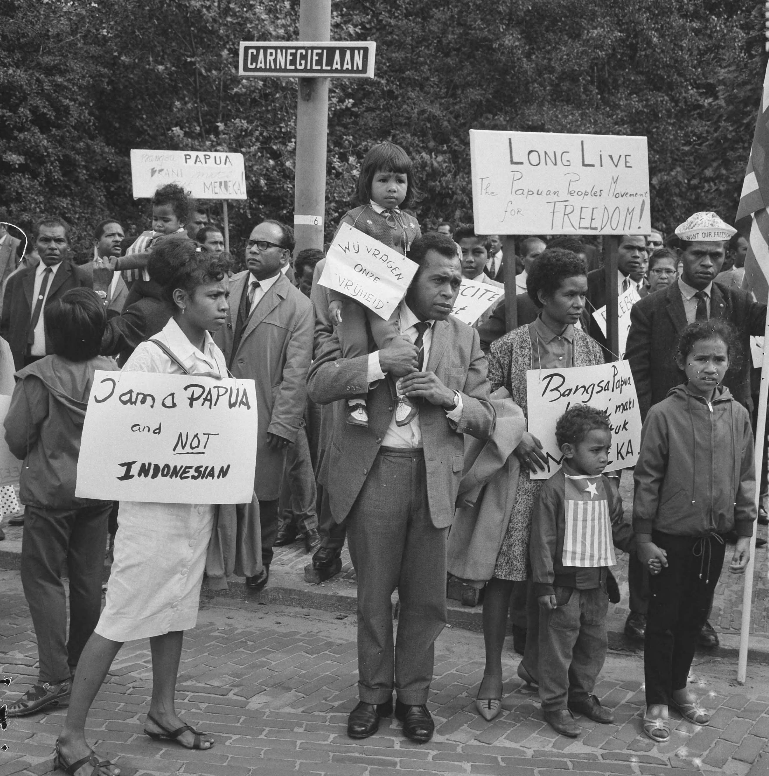 Fotocollectie Anefo — Papoea's demonstreren in Den Haag, Papoea's met protestborden in de Carnegielaan — Foto: Nijs, Jac. de / Anefo. Licentie: Set B: Rechtenvrij / Publiek Domein. Bron: Nationaal Archief. http://hdl.handle.net/10648/aabc6774-d0b4-102d-bcf8-003048976d84