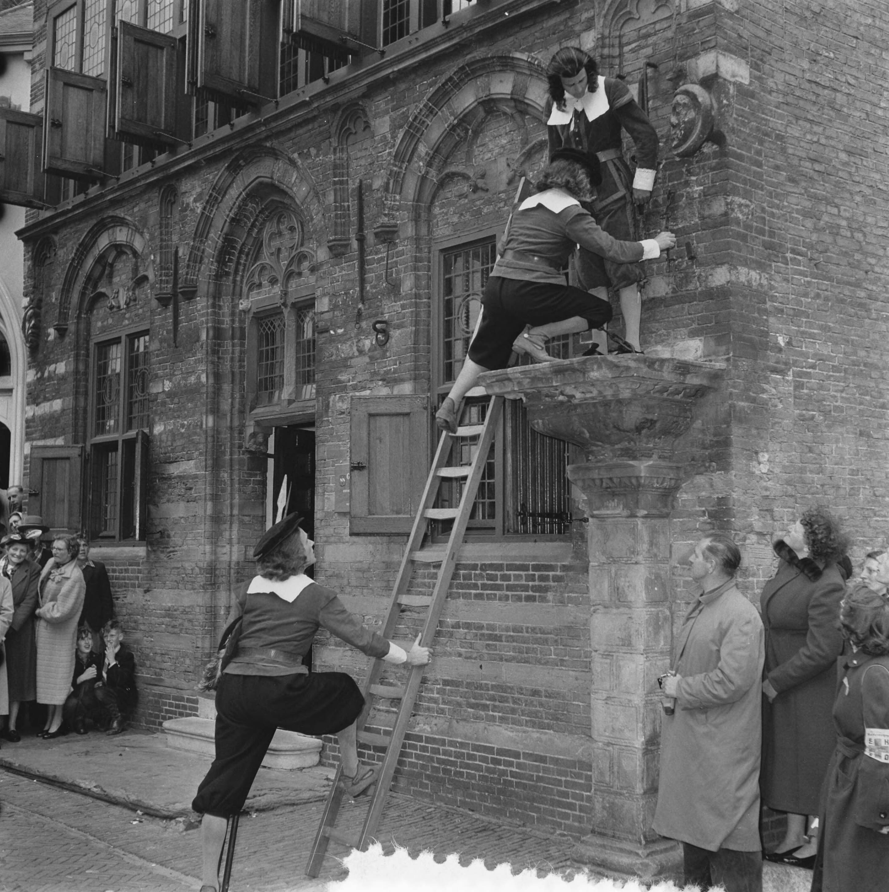 Koninklijk bezoek aan 15 gemeentes in Zuid-Holland (Rijnstreek en Merengebied) — Koningin Juliana en prins Bernhard bezoeken Woerden. Op de schandpaal van het oude gerechtsgebouw (gemeentemuseum) staat ene Gerrit de Goedere die op bevel van de koningin uit zijn benarde positie wordt bevrijd — Foto: Noske, J.D. / Anefo. Licentie: Set B: Rechtenvrij / Publiek Domein. Bron: Nationaal Archief. http://hdl.handle.net/10648/a92230f6-d0b4-102d-bcf8-003048976d84