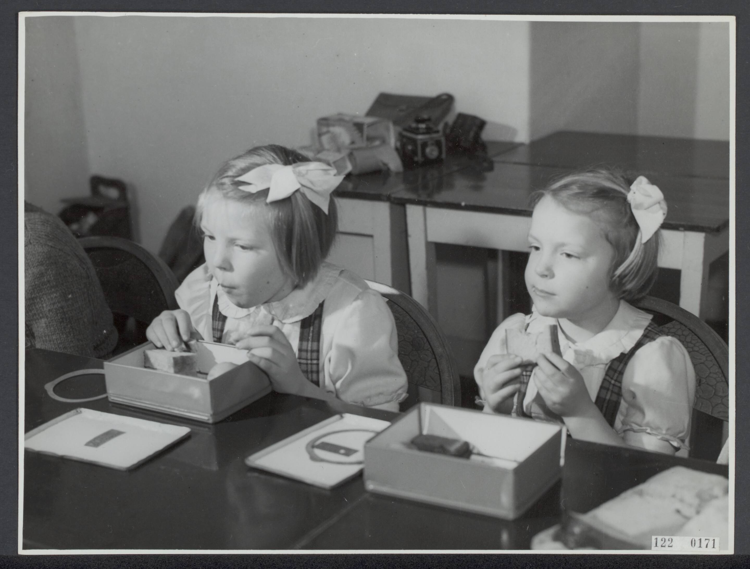 De prinsessen Beatrix en Irene op de Werkplaats Kindergemeenschap van Kees Boeke te Bilthoven — Prinses Beatrix en prinses Irene op de Werkplaats Kindergemeenschap van Kees Boeke te Bilthoven. De oudste prinsesjes eten hun boterhammen op de werkplaats — Foto: Breijer, Charles / Anefo. Licentie: Set B: Rechtenvrij / Publiek Domein. Bron: Nationaal Archief. http://hdl.handle.net/10648/af28d194-d0b4-102d-bcf8-003048976d84