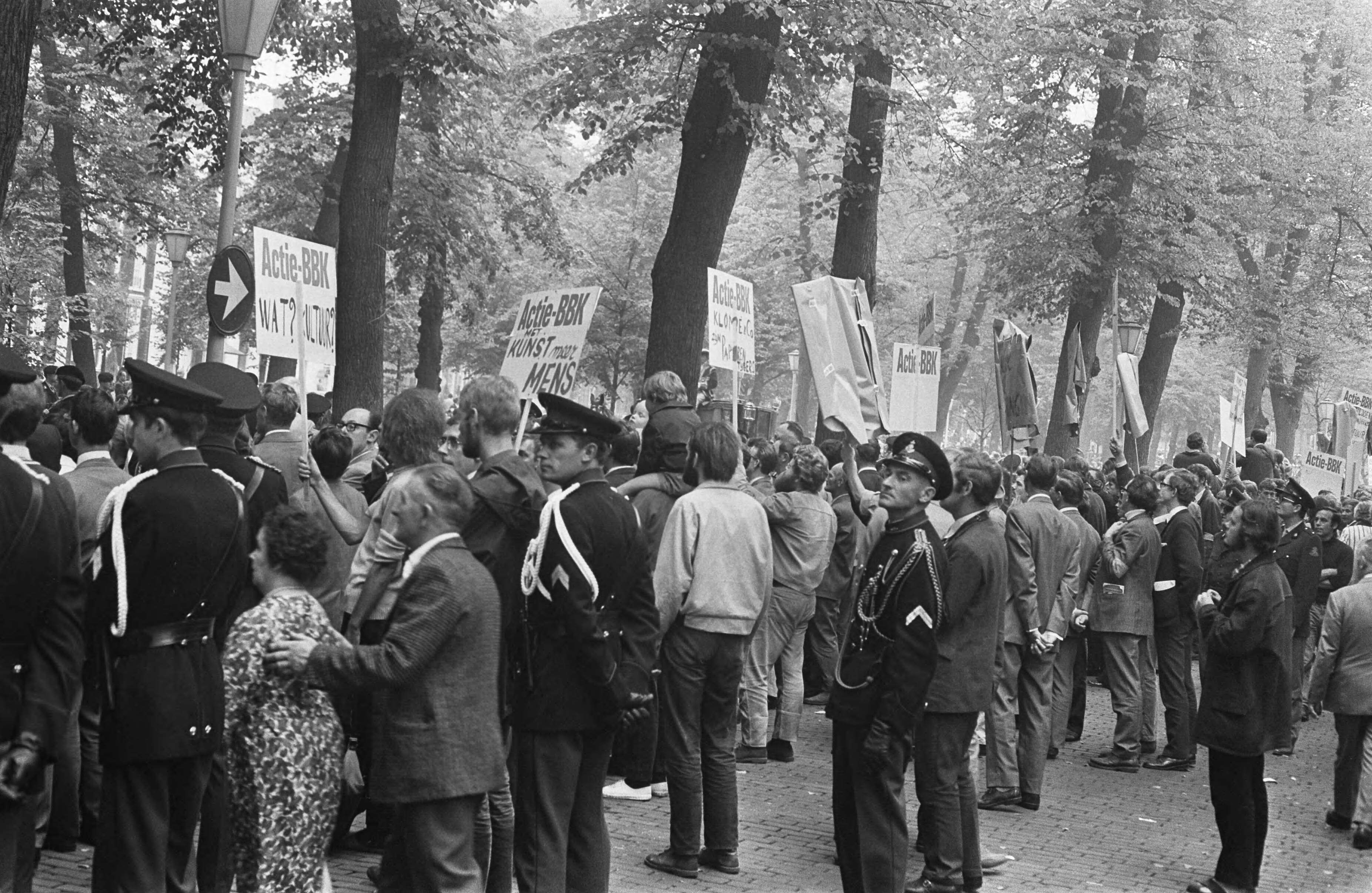 Fotocollectie Anefo — Kunstenaars van de BBK protesteren met borden tegen het cultuurbeleid op Lange Voorhout Den Haag tijdens rit Kon. Fam. naar Pal. Lange Voorhout : demonstrerende — Foto: Koch, Eric / Anefo. Licentie: Set B: Rechtenvrij / Publiek Domein. Bron: Nationaal Archief. http://hdl.handle.net/10648/ab79ff00-d0b4-102d-bcf8-003048976d84