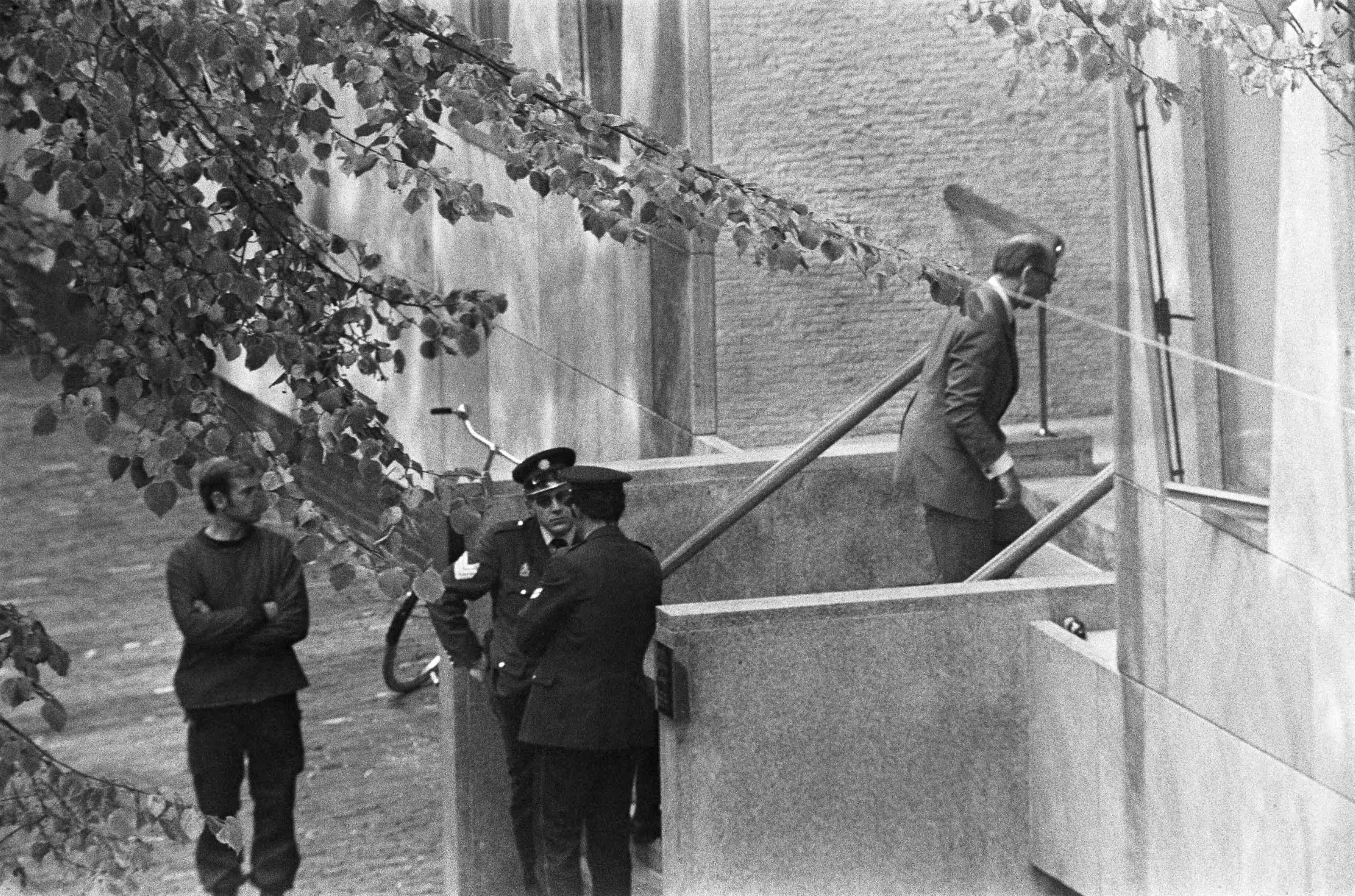 Fotocollectie Anefo — Gijzeling in Den Haag ; man in korte broek bij politie-agenten — Foto: Mieremet, Rob / Anefo. Licentie: Set B: Rechtenvrij / Publiek Domein. Bron: Nationaal Archief. http://hdl.handle.net/10648/ac556900-d0b4-102d-bcf8-003048976d84
