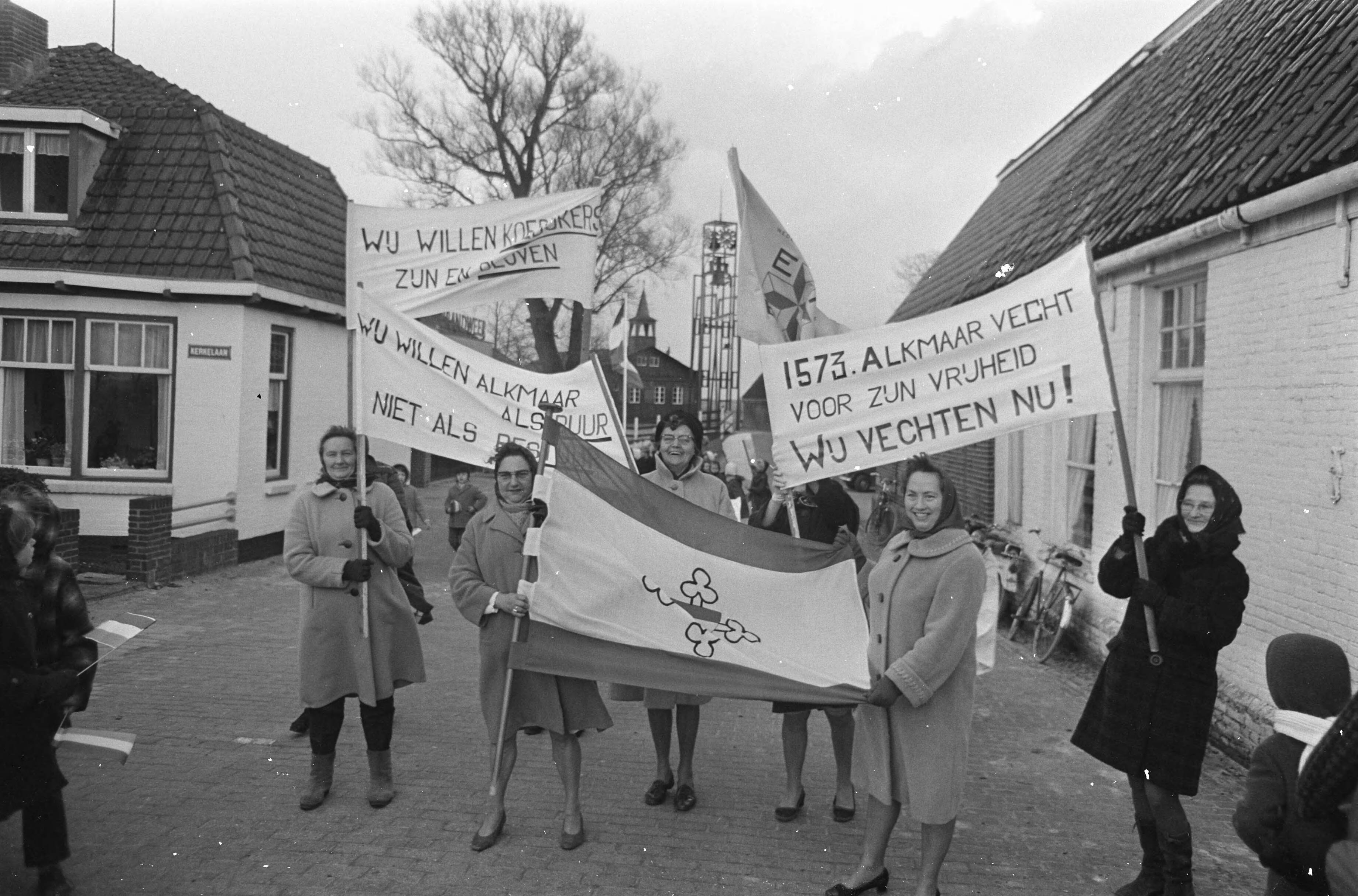 Fotocollectie Anefo — Demonstratie tegen annexatie van Koedijk en St. Pancras door Alkmaar mensen met bord — Foto: Nijs, Jac. de / Anefo. Licentie: Set B: Rechtenvrij / Publiek Domein. Bron: Nationaal Archief. http://hdl.handle.net/10648/ab5cdaba-d0b4-102d-bcf8-003048976d84