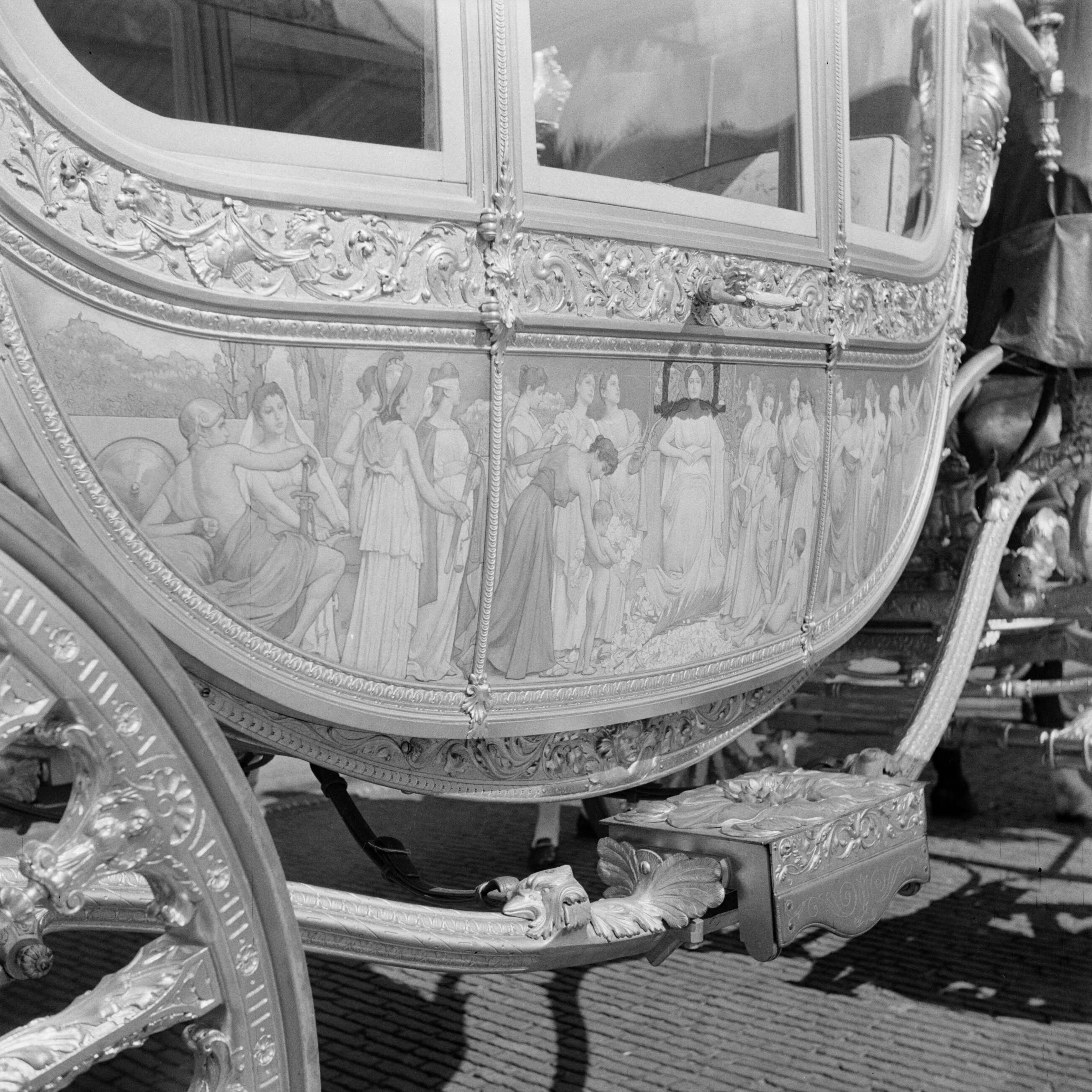 Troonsafstand koningin Wilhelmina / Inhuldiging van koningin Juliana — Voorbereidingen. Repetitie met de Gouden Koets, waarvan hier het rechter paneel, op de binnenplaats van het Koninklijk Staldepartement in Den Haag. — Foto: Poll, Willem van de. Licentie: Set B: Rechtenvrij / Publiek Domein. Bron: Nationaal Archief. http://hdl.handle.net/10648/aee70476-d0b4-102d-bcf8-003048976d84