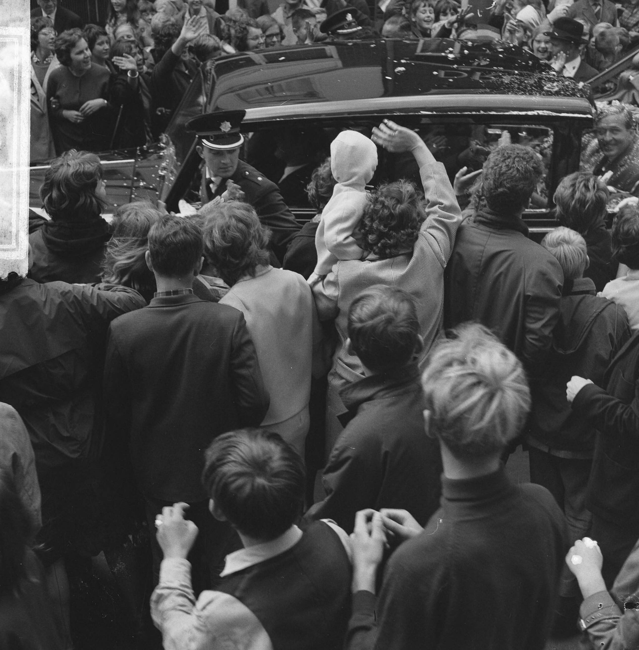 Fotocollectie Anefo — Prinses Beatrix en haar verloofde Claus von Amsberg brachten bezoek aan Zwolle, de hofauto met het verloofde paar omstuwd door publiek — Foto: Kroon, Ron / Anefo. Licentie: Set B: Rechtenvrij / Publiek Domein. Bron: Nationaal Archief. http://hdl.handle.net/10648/aabf7ff4-d0b4-102d-bcf8-003048976d84