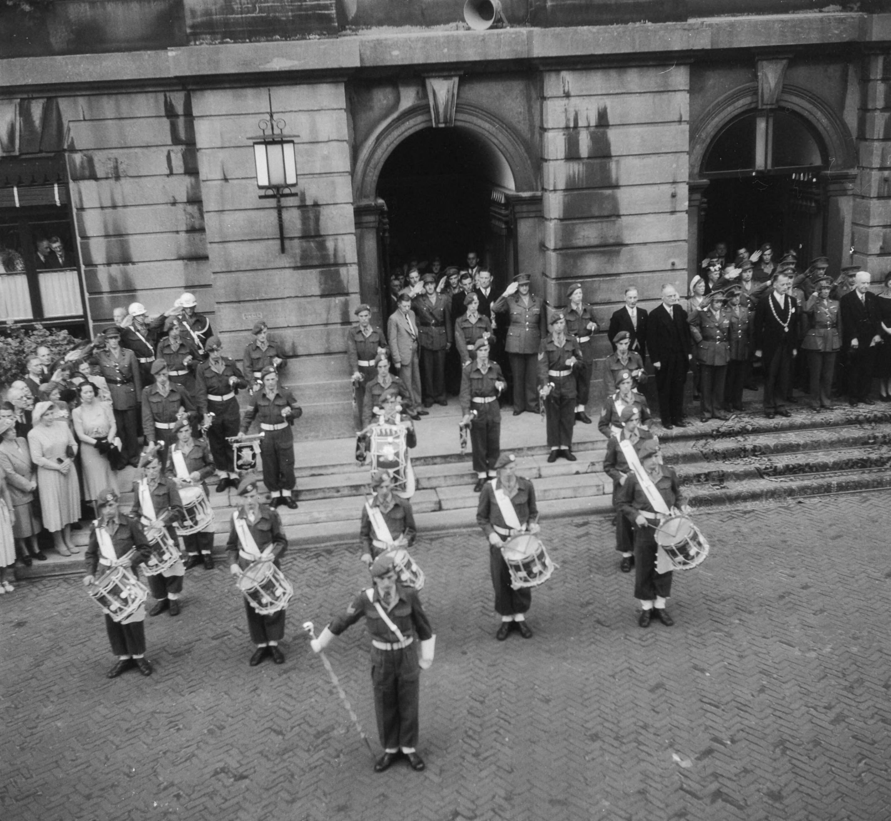 Fotocollectie Anefo — Nieuwe instrumenten voor de drumband van het Geniemuziekkorps overgedragen te Utrecht. Opgesteld voor het stadhuis — Foto: Oorschot, […] van / Anefo. Licentie: Set B: Rechtenvrij / Publiek Domein. Bron: Nationaal Archief. http://hdl.handle.net/10648/a8ddf4ae-d0b4-102d-bcf8-003048976d84