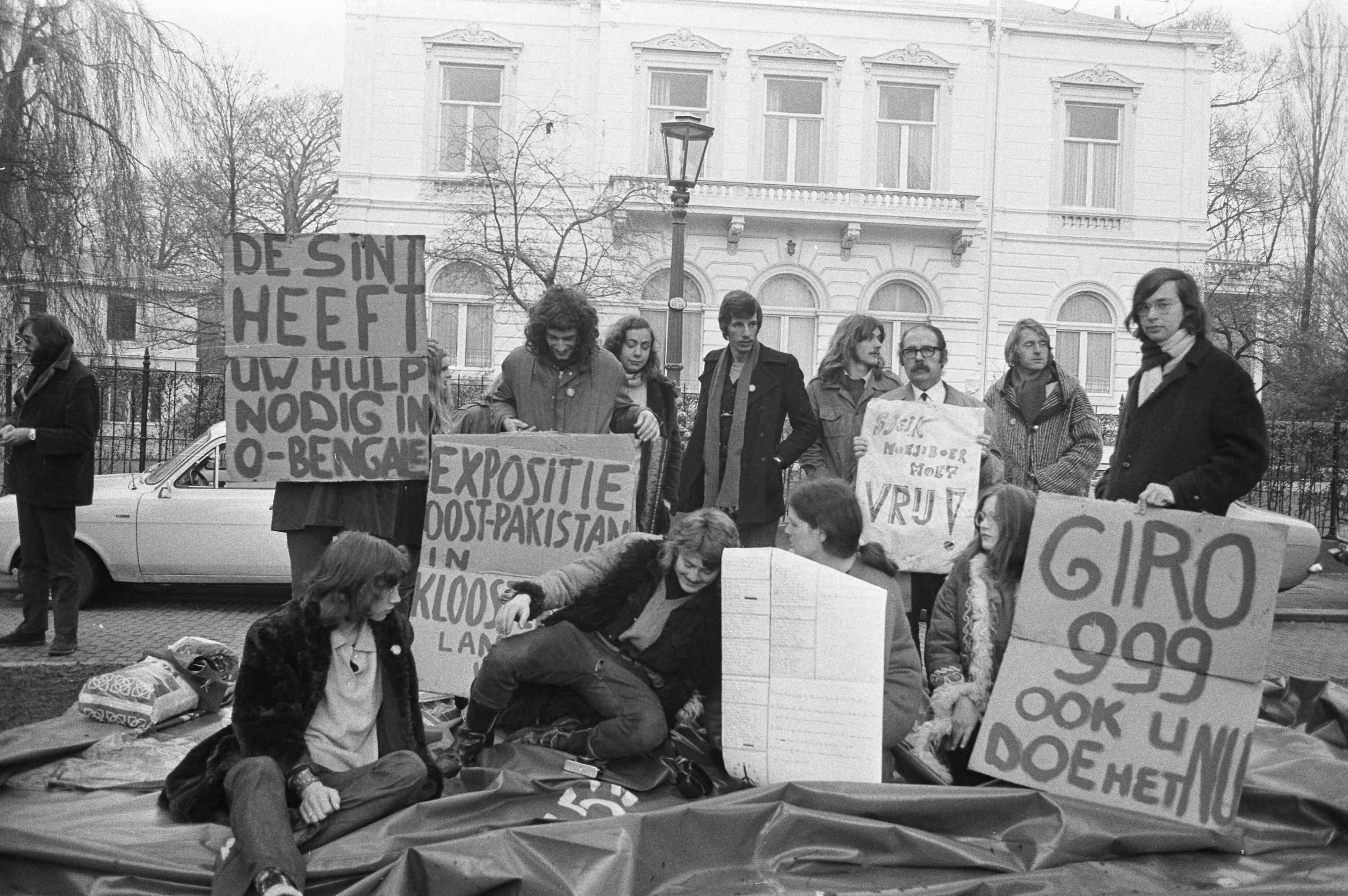 Fotocollectie Anefo — Demonstratie tegen beleid van regering van Pakistan bij ambassade van Pakistan in Den Haag , demonstranten met bord voor ambassade — Foto: Peters, Hans / Anefo. Licentie: Set B: Rechtenvrij / Publiek Domein. Bron: Nationaal Archief. http://hdl.handle.net/10648/abd978e0-d0b4-102d-bcf8-003048976d84