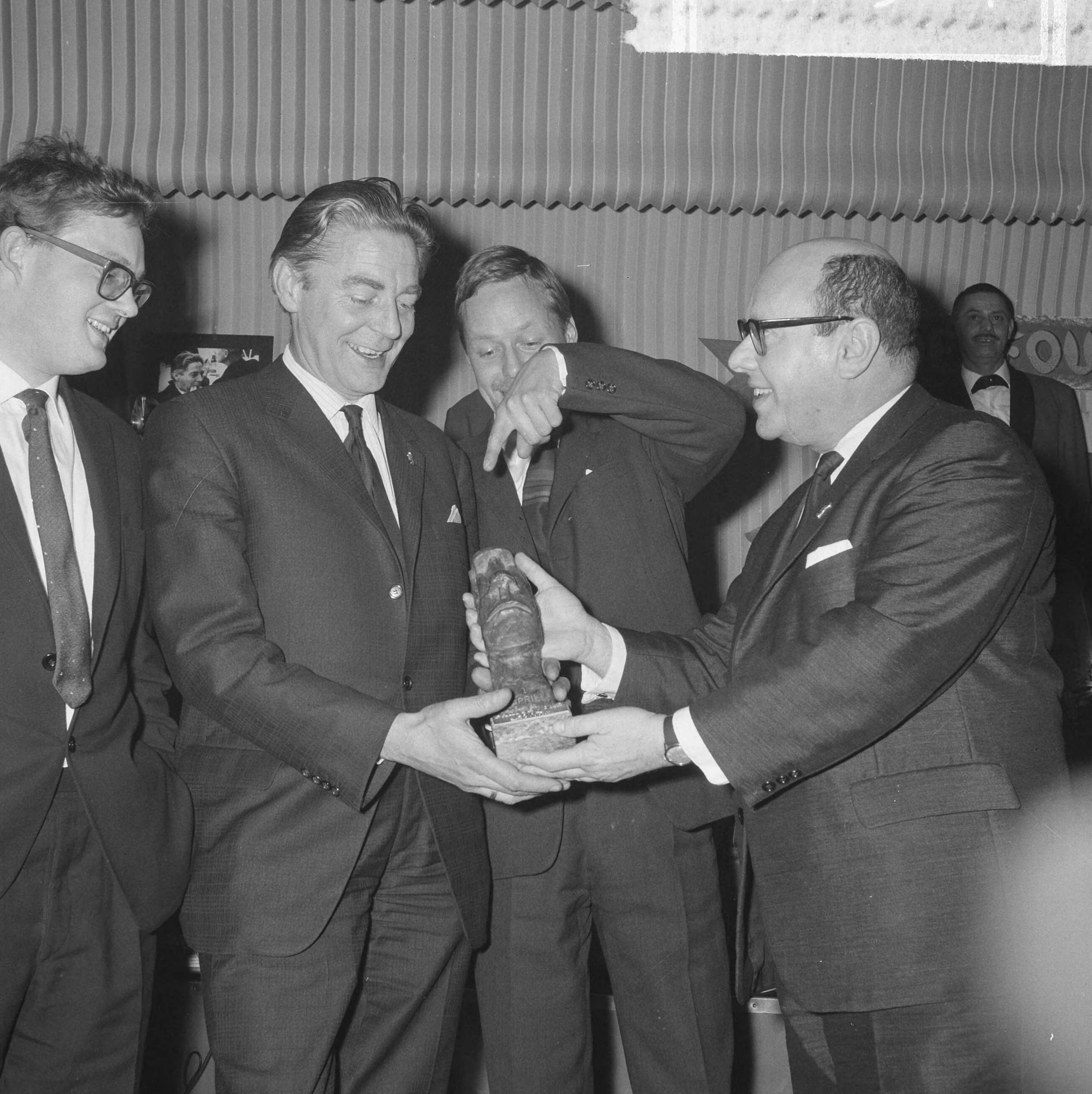 Fotocollectie Anefo — "Prix de Joke 1964" voor Bert Haanstra, Simon van Collem(rechts) reikt hem het beeldje uit in Hotel Bouwes te Zandvoort. [Links Rein van Rooij? 2e van rechts Peter Craghs? beiden lid van de jury] — Foto: Nijs, Jac. de / Anefo. Licentie: Set B: Rechtenvrij / Publiek Domein. Bron: Nationaal Archief. http://hdl.handle.net/10648/aa624be0-d0b4-102d-bcf8-003048976d84
