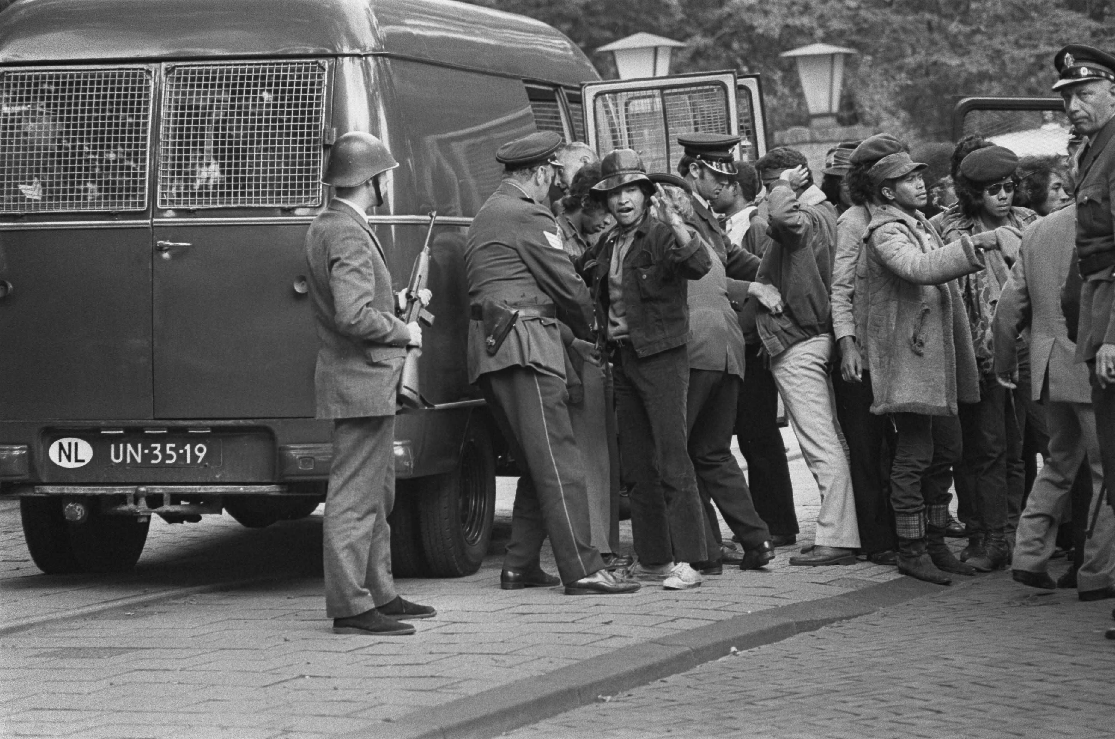 Fotocollectie Anefo — Ambonezen bezetten woning Indonesische Ambassadeur, Wassenaar; Ambonezen worden gefouilleerd voor ze politie-auto ingaan — Foto: Mieremet, Rob / Anefo. Licentie: Set B: Rechtenvrij / Publiek Domein. Bron: Nationaal Archief. http://hdl.handle.net/10648/aba1885e-d0b4-102d-bcf8-003048976d84