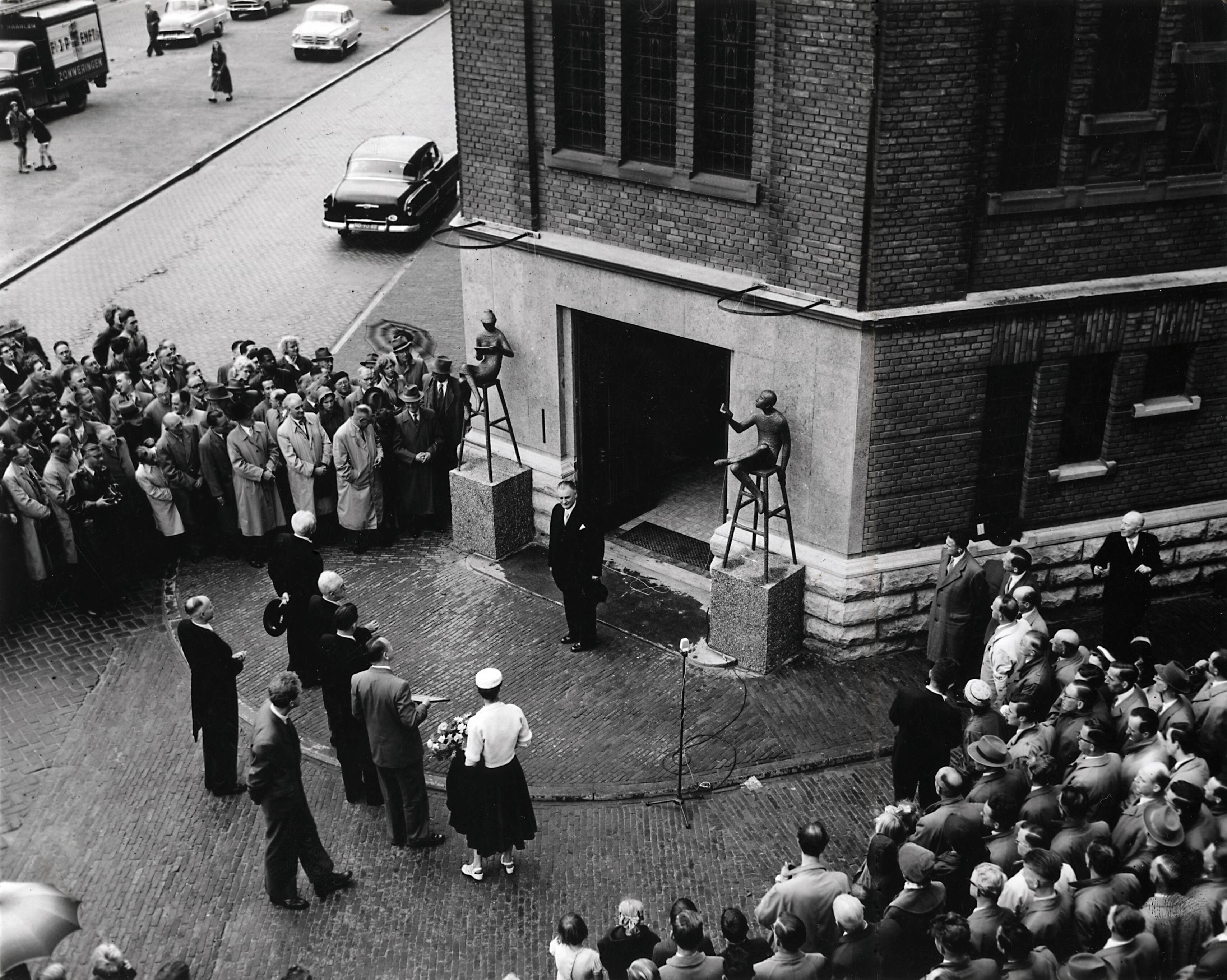 Collectie nader te bepalen — [50-jarig jubileum N.V. De Spaarnestad] [onthulling van de beelden van Hans Petri bij de hoofdingang van het Spaarnestadgebouw aan de Nassaulaan te Haarlem] — Foto: Fotograaf Onbekend / Fotobureau onbekend / Spaarnestad Photo (05887). Licentie: Set B: Rechtenvrij / Publiek Domein. Bron: Nationaal Archief. http://hdl.handle.net/10648/35429da6-3a89-a382-e063-6df0900a6686