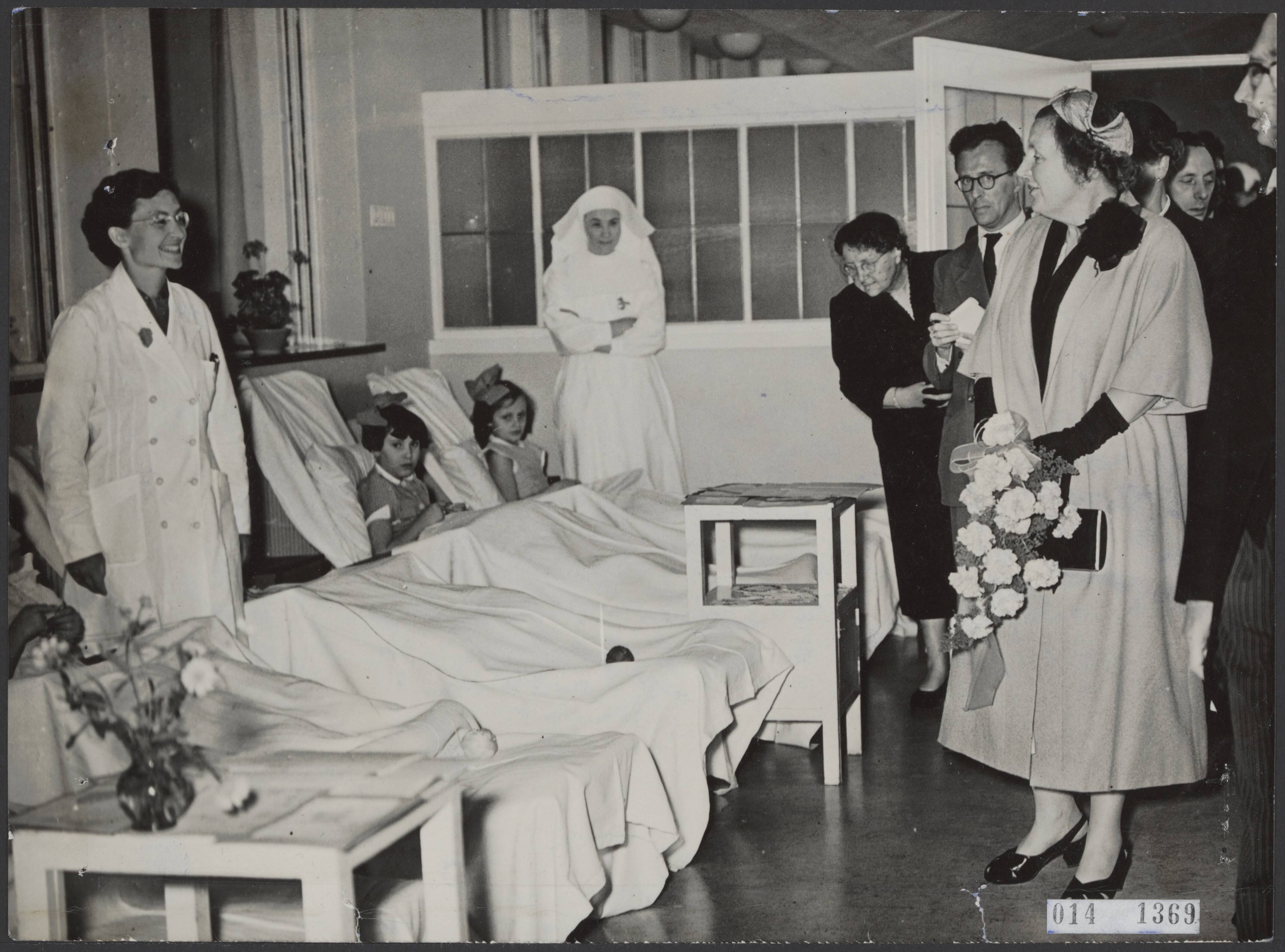 Fotocollectie Elsevier Binnenland — Bij Breda bracht koningin Juliana een bezoek aan het pas geopende sanatorium De Klokkenberg. Tijdens de rondgang op de kinderzaal — Foto: Fotograaf Onbekend / Anefo. Licentie: Set B: Rechtenvrij / Publiek Domein. Bron: Nationaal Archief. http://hdl.handle.net/10648/adb38ee4-d0b4-102d-bcf8-003048976d84