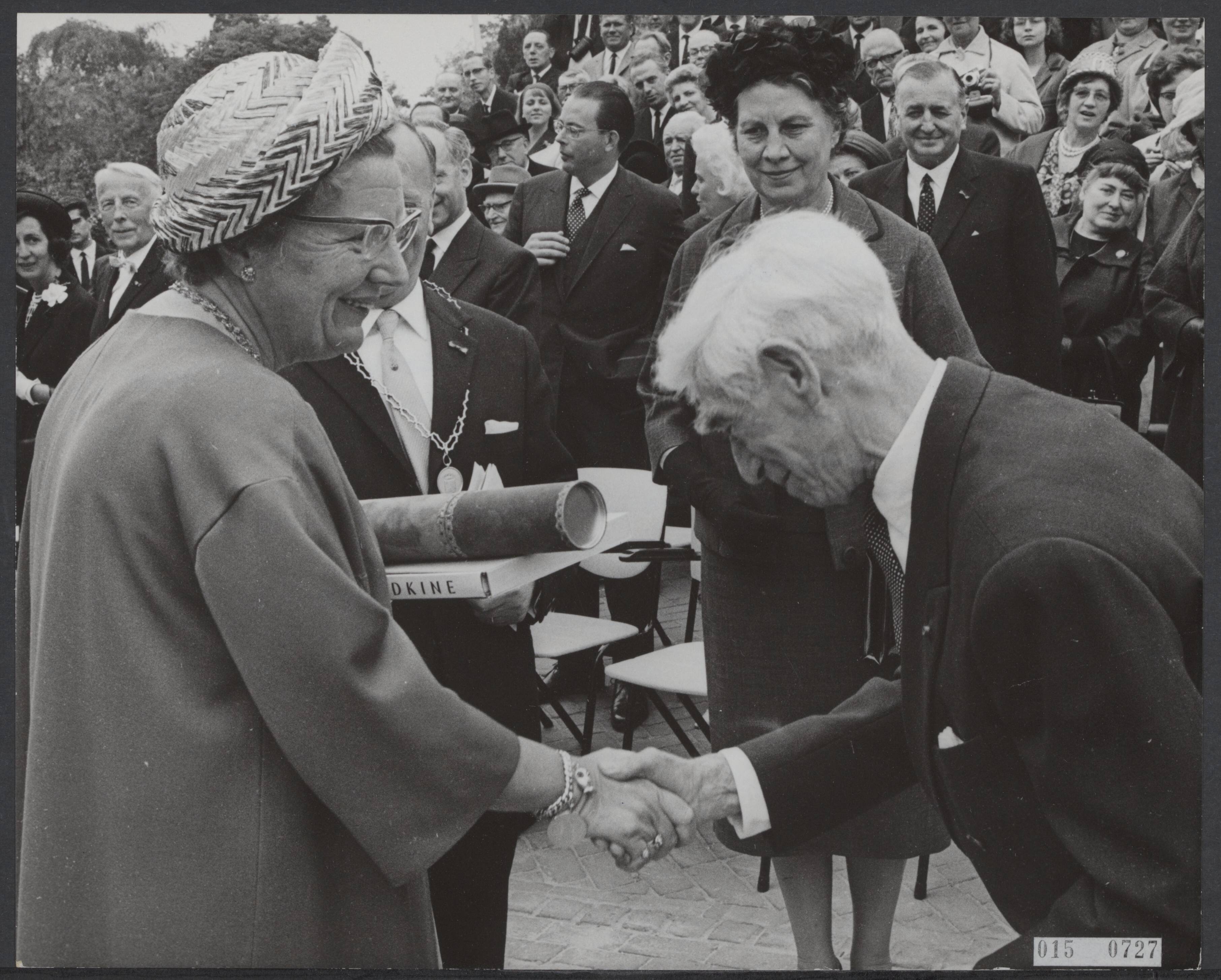 Fotocollectie Elsevier Binnenland — Koningin Juliana heeft in Zundert het Van Gogh monument onthuld. Geheel onverwacht overhandigde de maker van het monument, beeldhouwer Osip Zadkine, de koningin een pakje. Dit bleek een door hem vervaardigde gravure te bevatten die hij speciaal voor koningin had vervaardigd als een persoonlijk geschenk — Foto: Pot, Harry / Anefo. Licentie: Set B: Rechtenvrij / Publiek Domein. Bron: Nationaal Archief. http://hdl.handle.net/10648/adb5f62a-d0b4-102d-bcf8-003048976d84