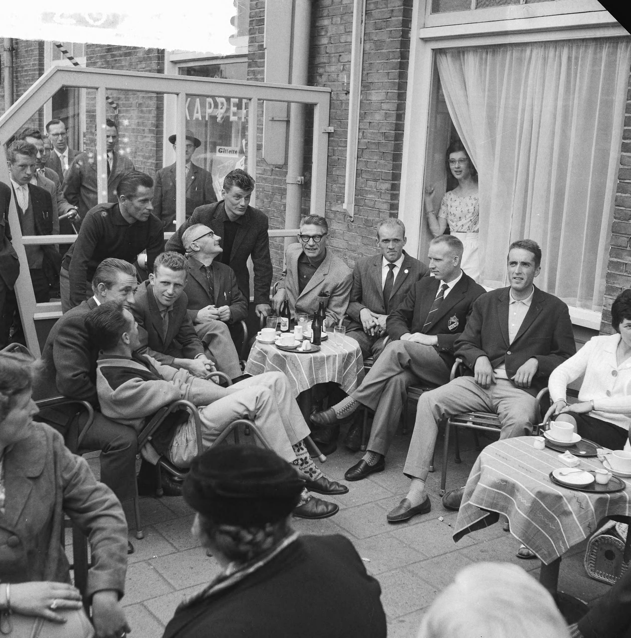 Tour de France 1961 — Vertrek Tour de France ploeg naar Frankrijk. De renners en officials op het terras. Zittend vlnr. Piet Damen, Wout Wagtmans, Jaap Kersten, verzorger, ploegleider Klaas Buchly, Coen Niesten, Piet van Est en Ab Geldermans. Staand Jef Lahaye en Jo de Haan — Foto: Koch, Eric / Anefo. Licentie: Set B: Rechtenvrij / Publiek Domein. Bron: Nationaal Archief. http://hdl.handle.net/10648/a9d9a4b6-d0b4-102d-bcf8-003048976d84