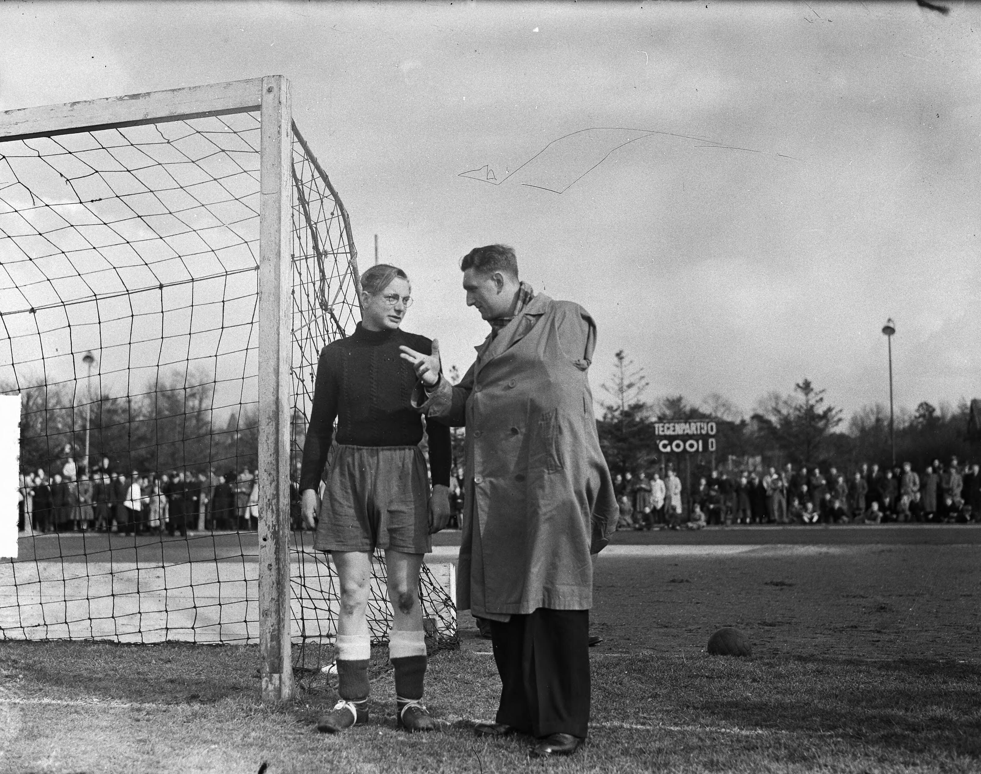 Fotocollectie Anefo — Voetbal. 't Gooi-Stormvogels 1-0. Piet Kraak, de geblesseerde 1e doelman van Stormvogels, geeft aanwijzingen aan zijn vervanger Hamers. — Foto: Merk, Ben / Anefo. Licentie: Set B: Rechtenvrij / Publiek Domein. Bron: Nationaal Archief. http://hdl.handle.net/10648/a8c4d942-d0b4-102d-bcf8-003048976d84