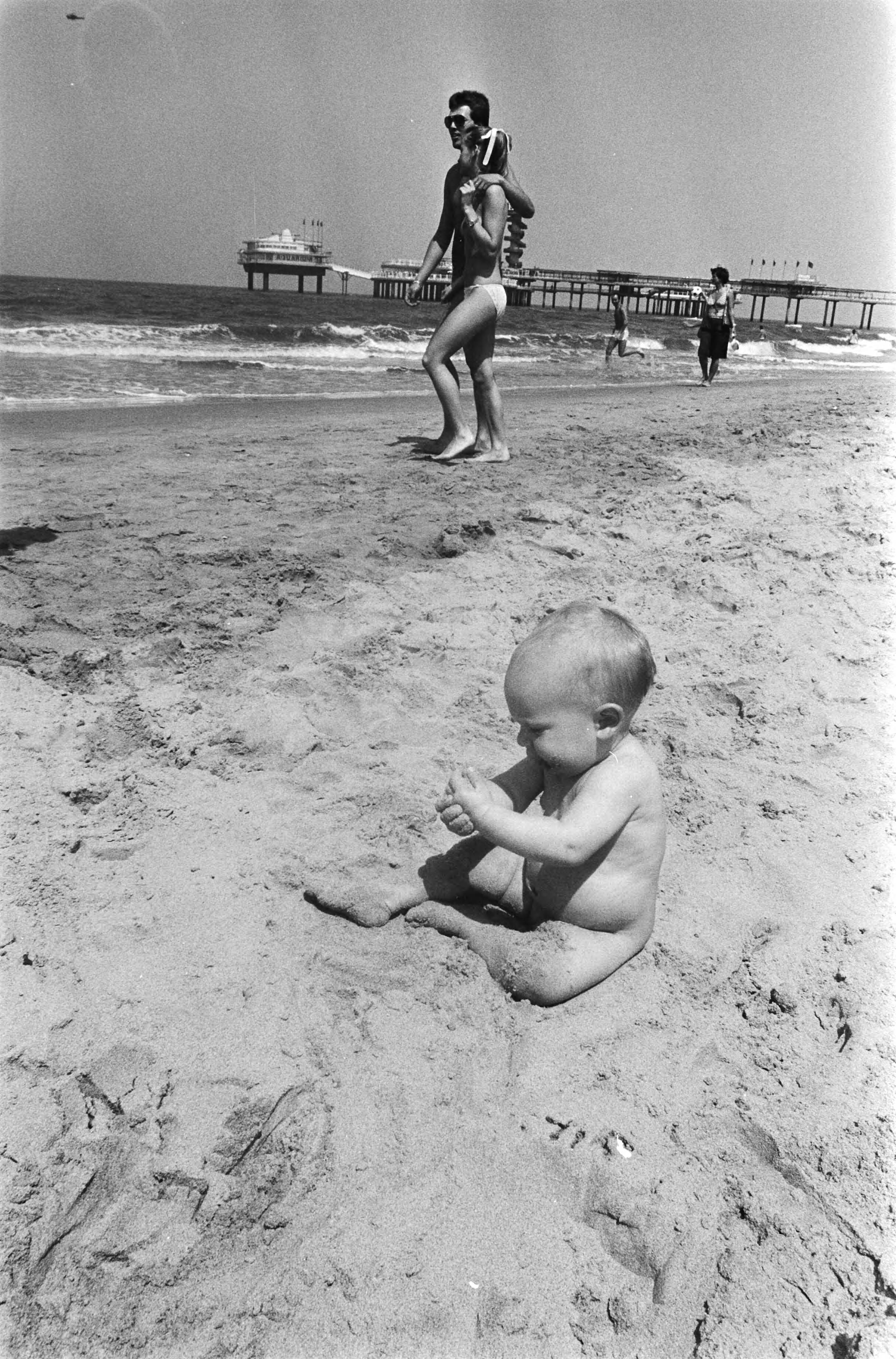 Strandweer — Baby aan strand van Scheveningen — Foto: Bogaerts, Rob / Anefo. Licentie: Set B: Rechtenvrij / Publiek Domein. Bron: Nationaal Archief. http://hdl.handle.net/10648/ad2ad96e-d0b4-102d-bcf8-003048976d84