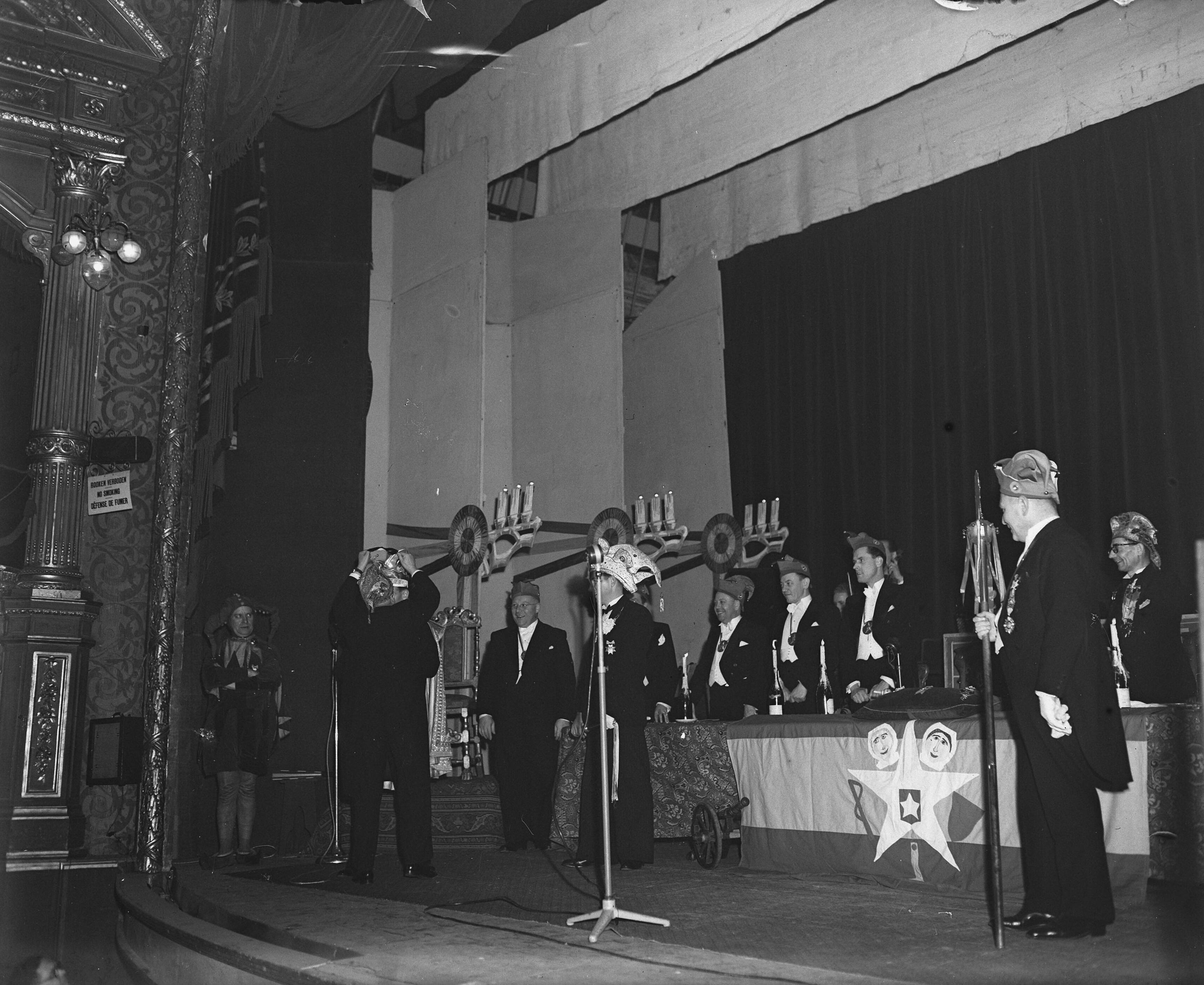 Fotocollectie Anefo — Uitroeping van Prins Carnaval 1948 te Maastricht. Voor de microfoon — Foto: Snikkers, Anton / Anefo. Licentie: Set B: Rechtenvrij / Publiek Domein. Bron: Nationaal Archief. http://hdl.handle.net/10648/a8b1b628-d0b4-102d-bcf8-003048976d84